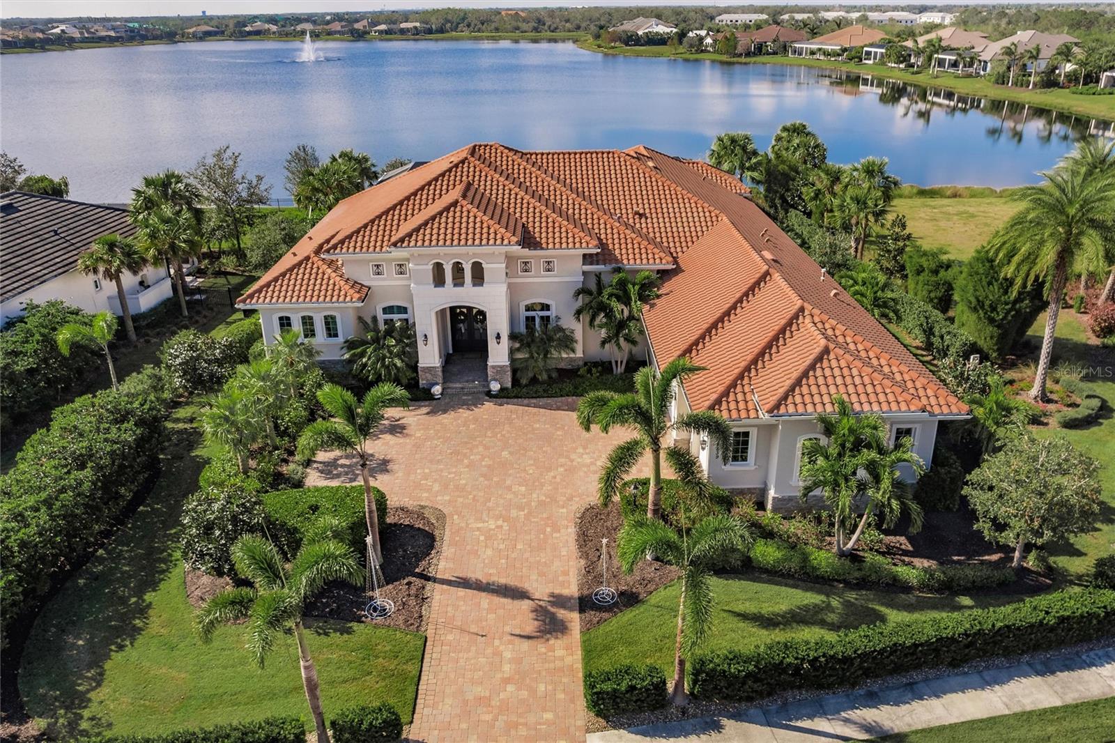 Absolutely stunning, one-of-a-kind dream home on Lake Como in The Lake Club. This extraordinary estate, nestled on a rare and private oversized lot along Lake Como, is surrounded by serene conservation areas and features breathtaking lake views from nearly every angle. Custom-designed landscaping ensures complete privacy, creating a tranquil oasis for the most discerning buyer. Exceptional Outdoor Living:
The heart of this home is the expansive 4,000-square-foot lanai, with 1,200 square feet under roof, doubling your living and entertaining space. Enjoy the travertine flooring, two outdoor fireplaces, a large mounted TV, and multiple sitting areas for relaxation or hosting. The centerpiece is the massive saltwater pool with a lap lane, spa, and extraordinary lighting. Adjacent to the pool, you'll find a dining area, outdoor kitchen, and enclosed pool storage room. Elegant Interior Design: Step inside through disappearing floor-to-ceiling pocket glass doors, seamlessly blending indoor and outdoor living. The great room features custom cabinetry and panoramic views of the lake. The formal dining room is complemented by a dry bar, perfect for entertaining. The home office/den boasts custom cabinetry and built-in workspaces with porcelain tile. The gourmet kitchen is a chef's dream, featuring two floating quartz islands, sub-Zero and Thermador appliances, custom soft-close cabinetry with glass tile backsplash, a coffee bar and walk-in pantry, and informal dining area with stunning lake views. Luxurious Private Suites: The master suite, located on a private wing, offers coffered ceilings, pool views, and two spacious walk-in closets. The spa-like master bathroom includes a double walk-in shower, soaking tub, and custom double vanities. On the opposite side, three additional bedrooms feature ensuite bathrooms and custom walk-in closets, ensuring comfort for family and guests. 
Extraordinary Features: 800-bottle wine room, insulated and refrigerated for the wine enthusiast. Designer touches: Coffered ceilings, tray ceilings, wall niches, custom lighting, fans, and wall coverings. This one-of-a-kind estate is for the fastidious buyer seeking unparalleled luxury, privacy, and sophistication. The owners invested $250k into significant improvements, including whole house generator, remote controlled hurricane shutters, motorized interior shades, landscaping, and fencing. The home was independently appraised last year at $3.8M. Don’t miss the chance to own this masterpiece in The Lake Club. Check out the 3D tour and schedule your private showing today!