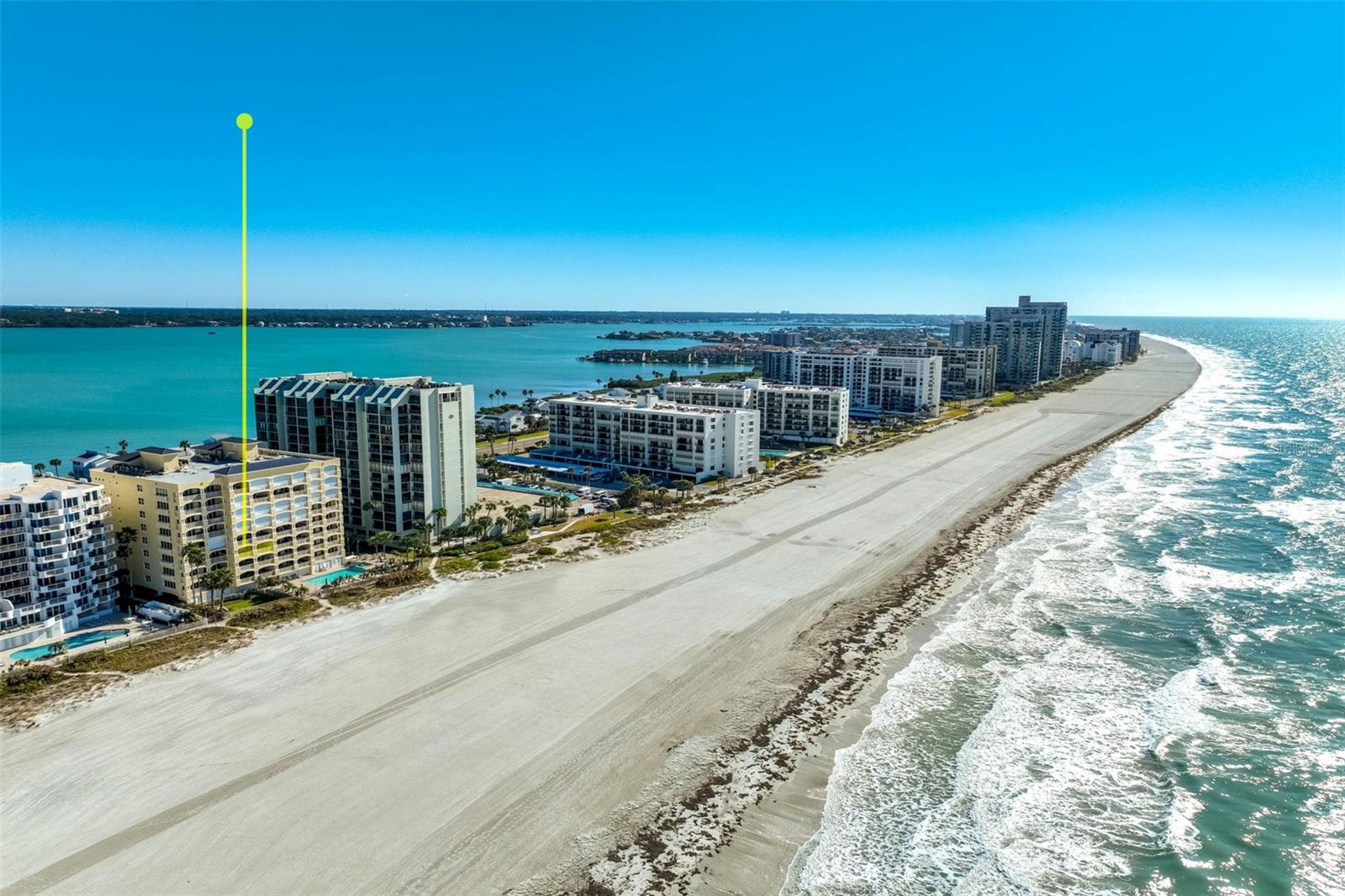 Experience elevated coastal living in this luxury boutique residence offering impressive square footage within a gated, exclusive 31-unit building. A rare and highly coveted feature in condominium living, this home includes a private garage PLUS an additional under-building parking space, an extraordinary combination seldom available.

Designer updated with current, high-end finishes throughout, this exceptionally spacious 3-bedroom, 3-bath residence showcases custom craftsmanship at every turn. The kitchen features custom-built cabinetry, premium finishes, and seamless flow into the living and dining areas, enhanced by modern recessed lighting that creates a bright, open atmosphere. Entertain effortlessly at the custom-built bar with dual wine refrigerators.

The primary suite is a true retreat, offering a spa-inspired bathroom with custom cabinetry, built-in wardrobe systems, thoughtfully designed drawer storage, and two walk-in closets. Every detail reflects quality, comfort, and refinement.

The second bedroom offers its own ensuite bath and private access to a rear balcony, creating an ideal guest retreat with added privacy. The third bedroom is equally spacious and beautifully appointed.

Impact-rated doors and sliders provide both security and energy efficiency, enhanced further by electric hurricane shades for added protection.

Step onto the deep, expansive balcony, large enough for both a full dining table and lounging chairs and take in the spectacular water views that define this residence. The setting delivers breathtaking scenery and unforgettable sunsets.

Residents enjoy resort-style amenities including a sparkling pool and fitness center, all within a luxury, well-maintained building. Just steps away, stroll to local shops and restaurants, escape to award-winning sugar-sand beaches, enjoy the energy of Clearwater Beach just minutes away, and reach the airport in approximately 30 minutes, making travel effortless.

A rare opportunity to own substantial square footage, unmatched parking, and refined coastal elegance in one exceptional address.