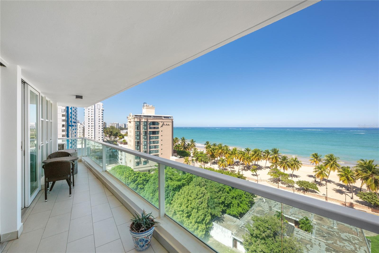 Own a piece of prime real estate at this ocean front condo in Isla Verde. This 1,800 sq. ft. 2 bedroom / 2.5 bath residence offers modern design with gorgeous views. The open-concept layout is ideal for hosting gatherings or enjoying quiet mornings with expansive ocean views and abundant natural light. Every detail was thoughtfully selected to create a home that feels both luxurious and inviting, from the high-end finishes to the intuitive smart-home features that enhance daily comfort. Sold fully furnished, move right in. 
The renovated kitchen serves as the centerpiece of the home, blending style and functionality with its quartzite countertops, sleek cabinetry, and top-of-the-line GE Monogram appliances. Whether preparing a casual breakfast or entertaining guests overlooking the Atlantic Ocean, the induction cooktop, beverage/wine refrigerator, and spacious layout enhance every culinary experience. Adjacent living and dining spaces effortlessly accommodate both intimate evenings and larger gatherings, all set against the backdrop of the building’s coveted beachfront location.
The primary suite is a true sanctuary, designed to offer privacy and tranquility. Its expansive en-suite bathroom features a double vanity, smart toilet, and modern fixtures that create a spa-like atmosphere. A generous walk-in closet provides ample storage and thoughtful organization. Secondary spaces - including the guest bedroom and additional bathrooms - maintain the home’s high standard of design, ensuring comfort and style for both residents and visitors.
Beyond the walls of the residence, the condominium’s beachfront location offers immediate access to San Juan’s pristine shores and vibrant lifestyle. Here, you can enjoy morning strolls along the coast, effortless access to dining and entertainment, and the serenity of oceanfront living - all from the comfort of a beautifully curated home that captures the essence of modern luxury in Puerto Rico. Amenities for this 11-story building include a pristine pool and fully equipped fitness center. 
Ocean View 903 and apartment Ocean View 904 next door, are both currently on the market separately. However, this is also a rare opportunity to acquire side-by-side ocean front properties together allowing the possibility for roughly 3,600 sq ft of living space and 5 bedrooms and 6 bathrooms. Call for more information.
