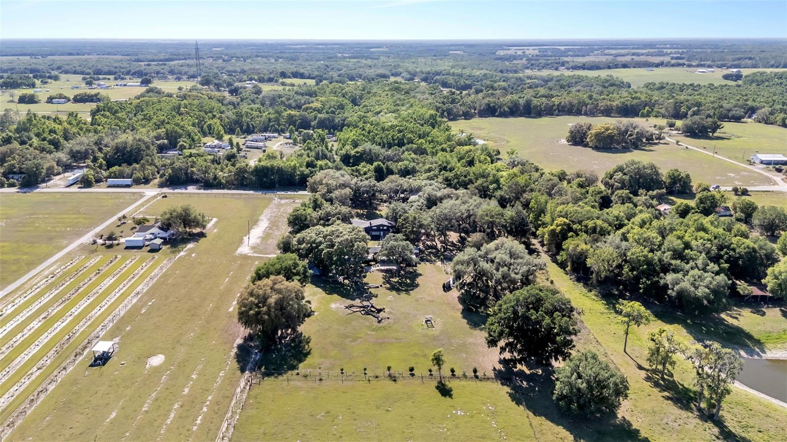 Welcome to a unique and versatile property located at 15300 Lake Iola Rd in Dade City—an established and award-winning event venue with endless potential. Formerly a flower nursery, this beautiful property now operates as a highly rated wedding and event venue, earning 5-star Google reviews and recognition as a Best Wedding Venue. The property offers parking for approximately 80 vehicles and multiple thoughtfully designed event spaces, including a wildflower ceremony area, dedicated reception space accommodating approximately 100 guests, and a dance floor area. The venue also features bridal and groom suites (bedrooms) complete with a full kitchen, two bathrooms, and a play area, along with separate outdoor restrooms for guests. The primary home is a charming three bedroom with three and half bath s, showcasing many original features, including the original exterior front door, a twin-stack fireplace, and a kitchen with the original double-stack stove. Additional updates include new carpet and a roof approximately 3 years old. Additional property highlights include an 830 sq ft basement, well pump was installed approximately 3–4 years ago, and septic system pumped approximately 2 years ago. The land has never been treated with pesticides, preserving its natural beauty and landscape. This property presents an incredible opportunity for event hosting, weddings, agritourism, or creative business ventures, all set within the peaceful charm of Dade City. The koi fish pond/ ceremony area will have stocked beautiful fish, although not all Koi fish will convey.