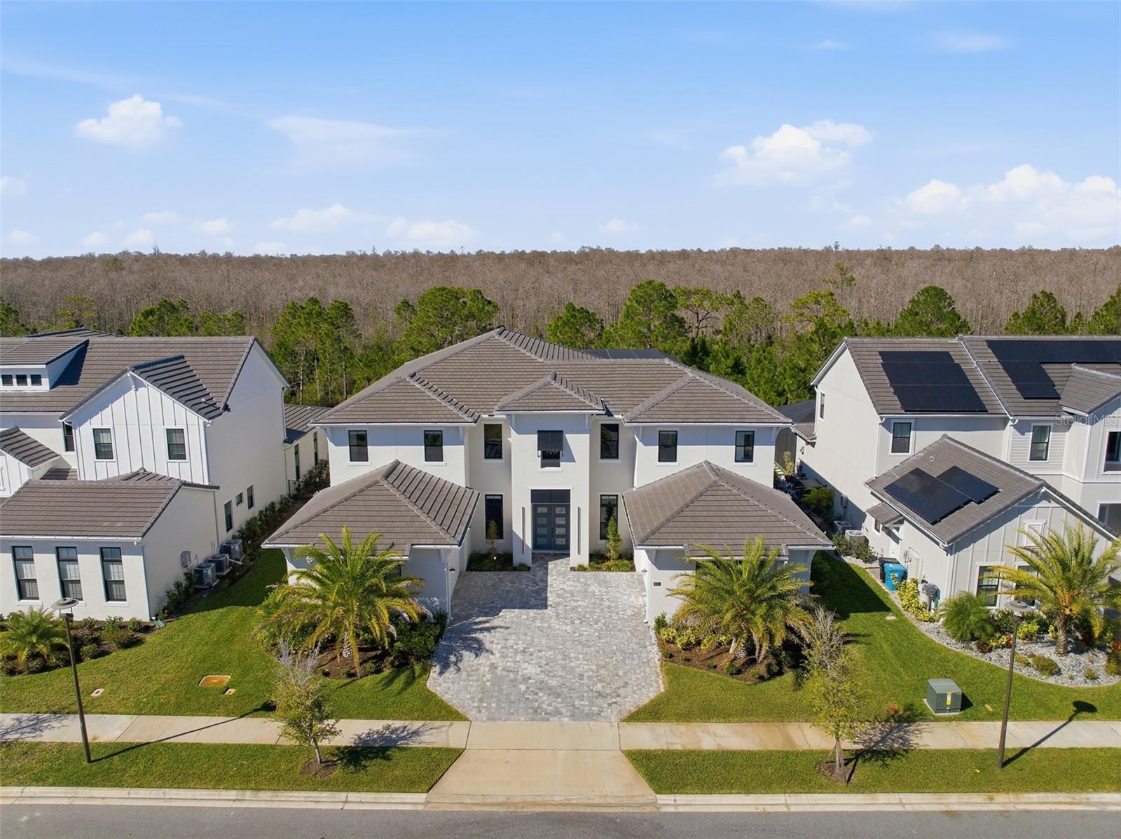 Under contract-accepting backup offers. Virtually Staged. HUGE Price Reduction!!!! Luxury, privacy, and an exceptional lifestyle converge in this extraordinary estate located within Laurel Pointe, Lake Nona’s exclusive 24-hour gated enclave of just 124 custom homes. Ideally positioned in the heart of Lake Nona, this home offers effortless access to Medical City, Boxi Park, Orlando International Airport, USTA, KPMG, premier shopping and dining, and is within two miles of SR-417 and SR-528, providing seamless travel throughout Central Florida. Built by Toll Brothers, this impressive VAREN Model sits on a lush, oversized conservation lot and showcases over $1,000,000 in thoughtfully curated upgrades, delivering a truly custom living experience. Constructed primarily of solid block on both levels and enhanced with additional insulation throughout (including both garages), the home features double-paned insulated windows, solid core interior doors, EV charging, dual 200-amp garage services with a 400-amp disconnect, and infrastructure designed for longevity, comfort, and efficiency. Spanning nearly 6,700 square feet, the open and light-filled floor plan offers five en-suite bedrooms, including the primary and a secondary suite on the main level, with three additional suites upstairs. Soaring 30-foot ceilings, dramatic dual wood staircases with modern custom railings, and premium finishes throughout create a striking first impression from the moment you enter through the covered entry and double front doors. The chef’s gourmet kitchen is a masterpiece, featuring professional-grade stainless steel appliances, extended custom cabinetry, a massive island with seating, glass inlays, accent lighting, built-in coffee and cappuccino machine, under-counter wine refrigerator, and a spacious walk-in pantry. Designer lighting, tray ceilings with crown molding, custom wall treatments, premium flooring, and floor-to-ceiling tile in every bathroom elevate the home’s refined aesthetic. Designed for both productivity and entertainment, the residence includes dual executive offices (one on each level), a spacious upstairs loft, and a massive media and movie room. Storage is abundant, complemented by two oversized double-car garages, each with insulated doors and private home entry. One garage features a custom mudroom adjacent to the large walk-in laundry room with utility sink, upgraded cabinetry, AV hub, and natural light.
The outdoor living experience is nothing short of spectacular. A $275,000 resort-style pool and spa with elevated retaining wall, spraying deck jets, bubbling sun shelf, and panoramic two-story screened enclosure overlooks a tranquil conservation backdrop. The covered lanai includes a full outdoor bath with shower, an incredible summer kitchen, and ample space for dining, entertaining, and relaxing in complete privacy.
Smart-ready and tech-forward, the home offers app-controlled pool systems, lighting, locks, enhanced WiFi with Cat-6 hard-wired connections, and built-in surround sound throughout the great room, kitchen, primary suite, and outdoor living areas. This is a rare opportunity to own a truly exceptional Lake Nona estate—one that seamlessly blends sophistication, comfort, privacy, and premier location to accommodate the most discerning buyer. Schedule your private showing and experience this remarkable home firsthand.