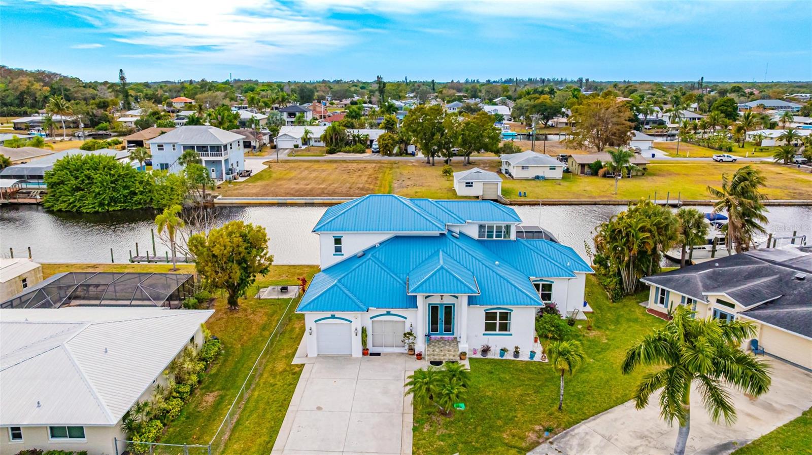 This exceptional deepwater canal residence offers just over 2,500 sqft and features four bedrooms and two-and-a-half bathrooms, complemented by an expansive enclosed pool+lanai area ideal for both relaxation and entertaining. The master bedroom on the first floor has a brand new walk-in closet and a large bathroom. The second floor displays three bedrooms, a full bathroom, and a covered lanai with a spectacular view of the water and the neighborhood. The home provides true peace of mind as it has never flooded and had a new roof installed in late 2022. The open-concept kitchen showcases custom cabinetry and granite countertops, all positioned to capture direct views of the canal. Outdoors, the spacious pool and lanai overlook an extensive captain’s walk and a 16,000-lb boat lift, making it the epitome of waterfront living. Situated on a wide, deepwater canal just seconds from the main river, the property offers direct Gulf access and an unparalleled boating lifestyle. Opportunities to own a waterfront home of this caliber—especially one with a proven history of remaining flood-free—are rare.
