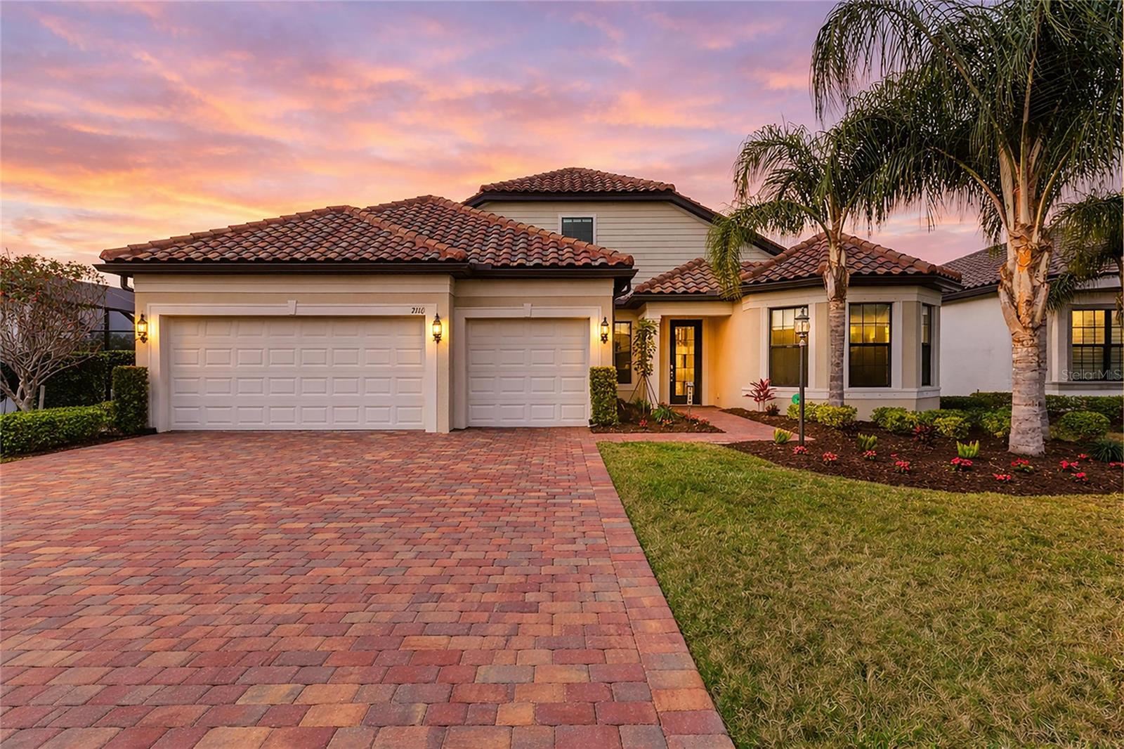 Welcome to your private sanctuary in Del Webb at Lakewood Ranch, where shimmering water views, golden sunsets, and resort-caliber living come together in perfect harmony. Set on an extra-deep cul-de-sac homesite, this expanded Stellar model with 4 bedrooms, 4 baths, and a flexible office space is designed for the way you want to live. From the moment you enter, your eyes are drawn beyond the main living space to a breathtaking panoramic lake view, framed by a panoramic screen that makes the outdoors feel like a living work of art. Imagine starting your mornings with coffee as the water glows in the early light and ending your evenings with spectacular sunset skies reflected across your custom pool and spa. The outdoor living experience is nothing short of extraordinary with an expansive paver lanai, a fully equipped outdoor kitchen, and generous gathering spaces that invite celebrations, quiet evenings, and everything in between. Enjoy safety with electronic hurricane shades in lanai. This is where memories are made. At the heart of the home, the chef’s kitchen is both stunning and practical, with glazed ivory cabinetry, quartz countertops, an impressive 11-foot breakfast bar, and top of the line KitchenAid appliances. Whether hosting holidays, intimate dinner parties, or casual brunch with friends. Throughout the home you’ll find crown molding, tray ceilings, designer lighting, and custom window treatments elevating the space with warmth and sophistication, while the thoughtfully designed layout offers the privacy and comfort you and your guests deserve. The upstairs is complete with bonus room, bedroom and bathroom making this the perfect retreat for visiting family, long-term guests, or a peaceful escape all your own. Even the oversized 3-car garage has been enhanced for real life, with abundant storage and a custom workbench for hobbies, projects, and organization. Beyond your front door, life unfolds in the vibrant, amenity-rich Del Webb community where you can enjoy morning fitness classes, afternoons by the resort pool, pickleball with neighbors, art studio creativity, evening events, and a full-time lifestyle director curating experiences that turn neighbors into lifelong friends. And all of this is set within Lakewood Ranch, where waterside dining, boutique shopping, farmers markets, championship golf, cultural events, and the Gulf Coast’s world-famous beaches are just moments away. This is more than a home, it’s where your next chapter feels like a permanent vacation. For extra peace of mind sellers providing a one year home warranty. Start living the life you deserve in this exceptional home.