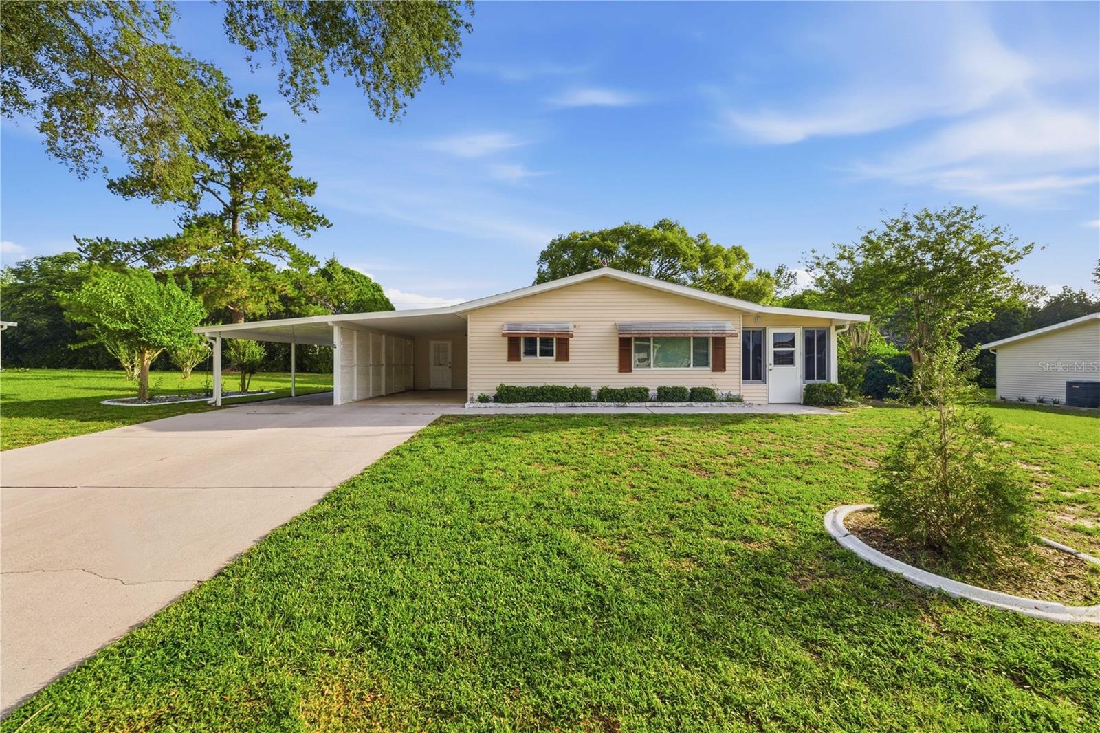 Welcome to this lovingly maintained 2-bedroom, 2-bath home situated on a spacious .25-acre lot in the desirable 55+ community of Spruce Creek North. Move-in ready and thoughtfully updated, this charming home offers two carports, a dedicated storage/laundry room, a detached shed, and beautiful mature landscaping accented by concrete landscape curbing. Step inside to a bright, open-concept living and dining area featuring attractive laminate flooring throughout, neutral colors, and large windows that fill the home with natural light. The spacious kitchen overlooks the main living area and offers abundant cabinetry, generous countertop space, and granite countertops. Both bathrooms have been refreshed with updated features, including granite vanity tops, providing a clean and modern feel. The home's well-designed layout maximizes both comfort and functionality, making everyday living and entertaining effortless. Just beyond the living area, sliding glass doors lead to a sun-filled Florida room complete with a portable A/C unit, walls of windows, and peaceful views of the surrounding landscape. This versatile space is perfect for morning coffee, relaxing with a book, or hosting guests year-round. Additional updates include a new roof in 2021 and replacement windows in 2019, offering peace of mind for years to come. With its combination of tasteful updates, spacious lot, and exceptional care, this home is a wonderful opportunity to enjoy the active lifestyle and community amenities that Spruce Creek North has to offer. Spruce Creek North is known for its low-maintenance lifestyle and active amenities, including a community pool, clubhouse, fitness center, library, billiards, bocce ball, shuffleboard, game room,  a full calendar of year-round social activities, tennis and racquetball courts, walking paths,  low cost RV Boat lot on site, and security patrol.  All of this with an affordable monthly HOA fee that includes  trash pickup, basic cable and common area and maintenance .  Conveniently located near shopping, dining, medical facilities, and SR-200 & I75, yet within a quite serene neighborhood.  This home is move in ready!