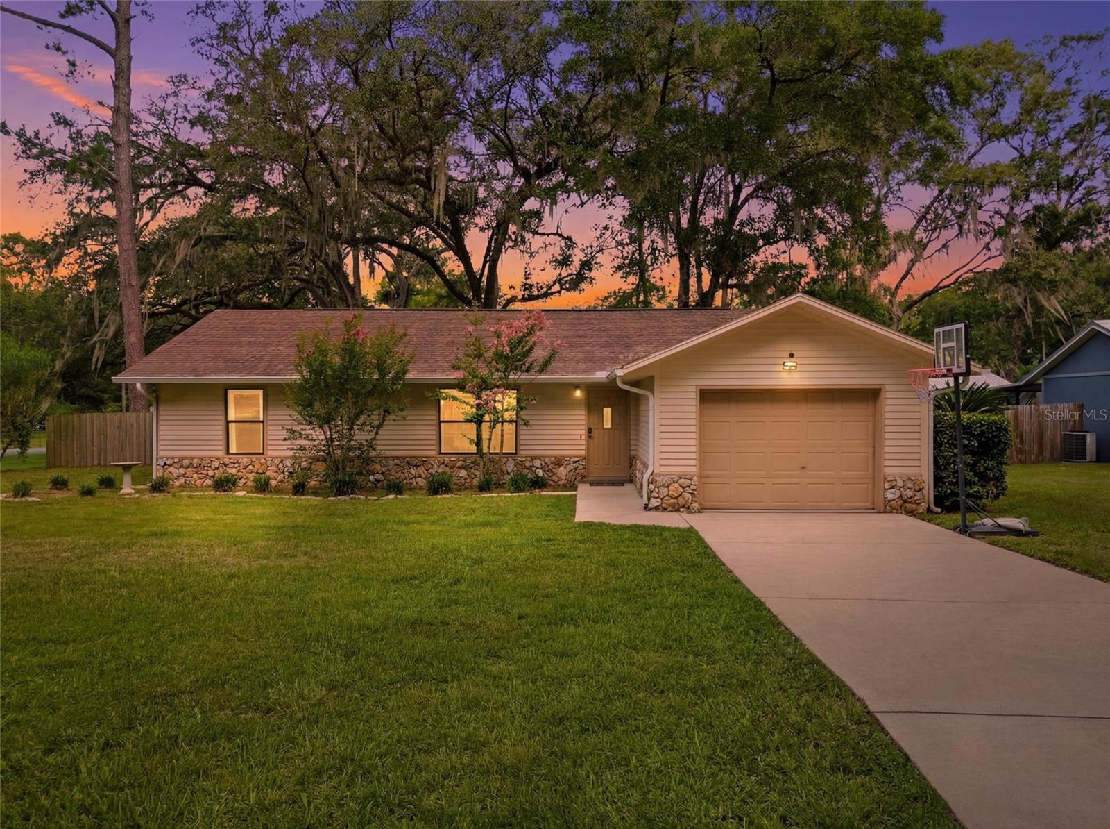 Welcome to this beautifully maintained 3-bedroom, 2-bathroom home, ideally situated on a spacious lot surrounded by mature trees and lush greenery, offering a peaceful setting with plenty of room to relax or entertain. The home's well-lit exterior enhances both its curb appeal and functionality, creating a warm and inviting atmosphere after sunset.

Inside, you'll find a bright, functional layout featuring stainless steel appliances, ceiling fans throughout, and an attached garage for added convenience.

Enjoy peace of mind with numerous recent updates, including a 2019 roof, 2023 A/C system with an in-duct UV air purifier, and a 2024 septic tank. Located just 10 minutes from the World Equestrian Center, this home offers the perfect balance of tranquility and accessibility. Conveniently located near shopping, dining, and medical offices, with easy access to I-75, you'll enjoy seamless travel to Orlando, Tampa, and Gainesville. Whether you're looking for a primary residence or a home close to one of the area's premier destinations, this property is a fantastic opportunity.