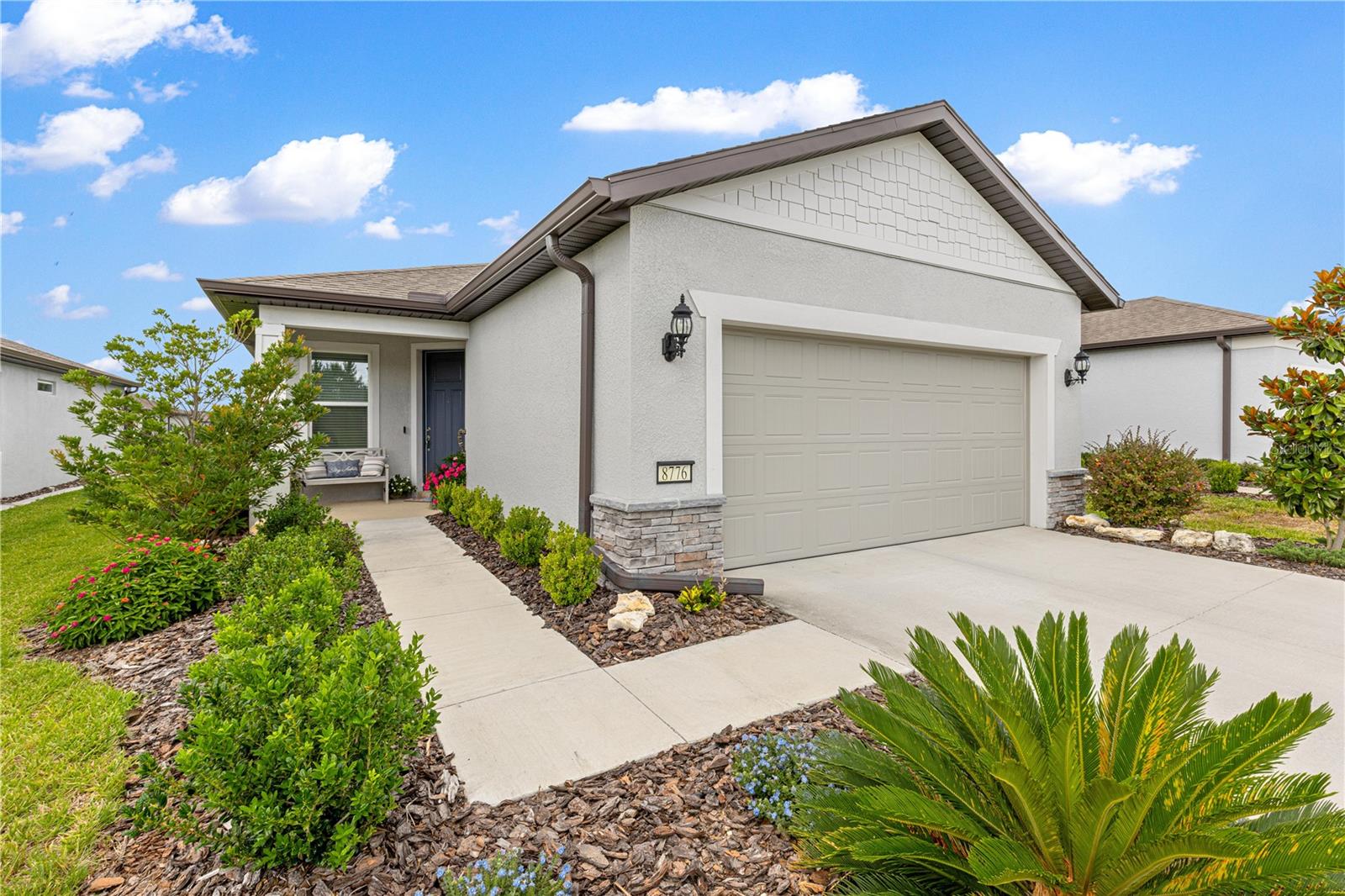 Imagine spending your mornings sipping coffee on your extended covered and screened lanai, cooled by dual ceiling fans, something rarely found in a garden home. Cedar trees and 5 -6-foot-tall hedges provide privacy from the rear neighbors. Welcome to easy living in this better than new Contour model in the sought-after community of Stone Creek! Designed to maximize every square foot, this beautifully appointed home shows like a model and offers an open-concept floor plan that feels spacious, bright, and inviting. The heart of the home features timeless white kitchen cabinetry, elegant quartz countertops, designer lighting, and neutral finishes that create a warm backdrop for any decorating style. The living area seamlessly connects to the outdoor space through triple sliders enhanced with a convenient electric shade, making indoor-outdoor living effortless. The bedrooms offer excellent storage, both having 8 foot doors and walk-in closets, while additional storage solutions throughout the home ensure everything has its place. Potential buyers will appreciate the extended garage, complete with epoxy-coated floors, overhead storage, plumbed for a water softener and boasting an insulated garage door for added comfort and efficiency. Even the laundry room has been thoughtfully designed with additional cabinetry for organization and convenience. Here, you'll enjoy the freedom of a low-maintenance lifestyle with HOA benefits that include lawn care, irrigation, and high-speed Spectrum internet with more than 250 premium TV channels. It's the perfect blend of comfort, convenience, and peace of mind. This is more than a home—it's a place where you can simplify your life without sacrificing the space, storage, and features that matter most. Come discover how beautifully "living large in a small footprint" can feel. You can't build a new home with all these features for anywhere close to this price!  Property is agent owned. Stone Creek is a 55plus resort-style golf cart friendly community, with almost 200 clubs and interest groups, an active Lifestyle office which provides many entertainment options, 2 pools (and another one being built) a spa, a club with large bar overlooking a lake, and a variety of sports, including pickleball and golf.