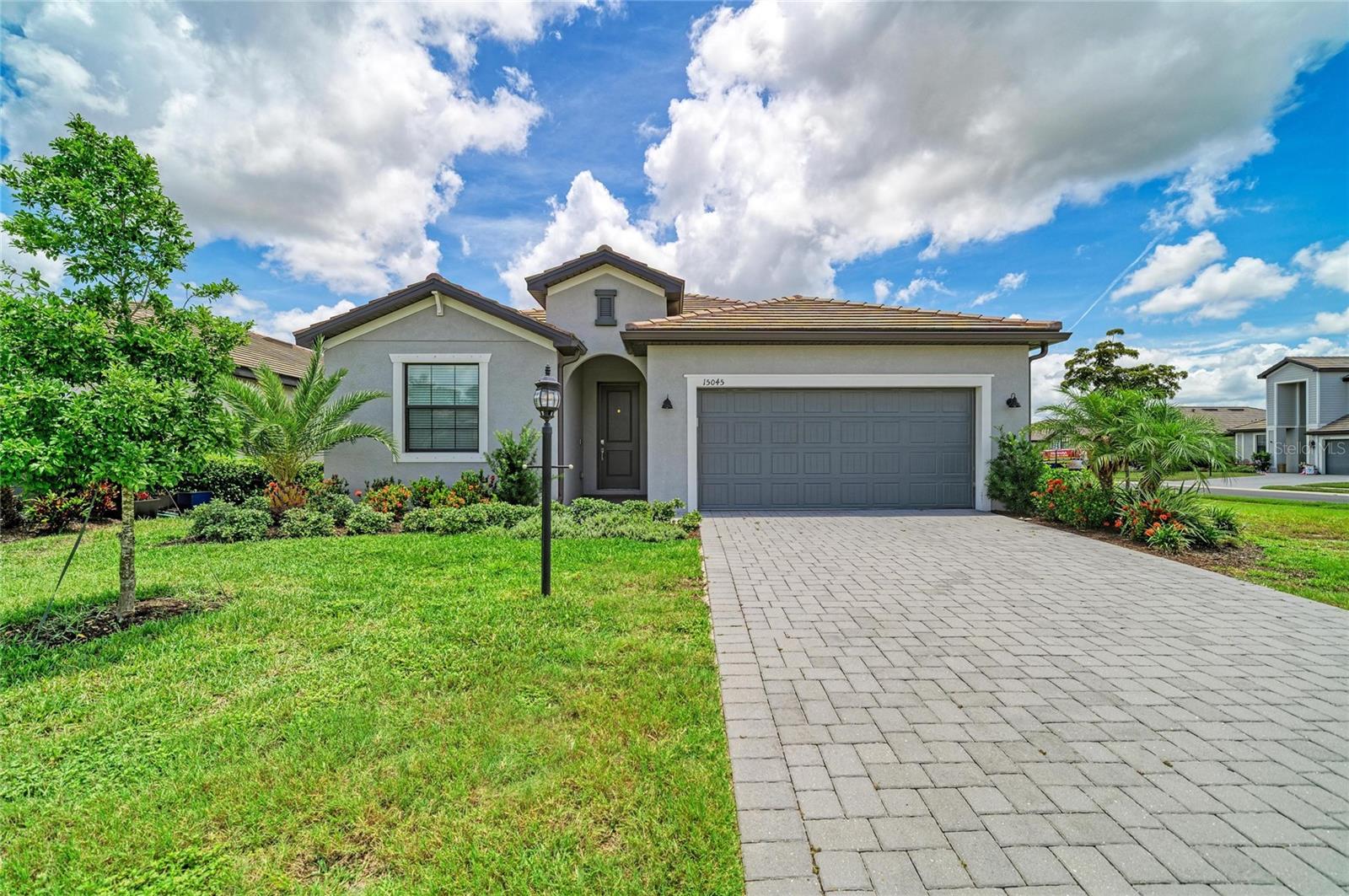 Skip the wait to build and start enjoying the Lakewood Ranch lifestyle today at 15045 Serene Shores Loop. Built in 2024, this beautifully upgraded Marsala model is perfectly positioned on a desirable corner lot with partial lake views in the gated community of Lorraine Lakes. Offering 3 bedrooms, 3 full bathrooms, a private den with French doors, and 2,202 square feet of thoughtfully designed living space, this move in ready home blends modern style with everyday functionality. The open concept floor plan features upgraded tile flooring, designer lighting, upgraded ceiling fans, quartz countertops, stainless steel appliances, natural gas cooking, an oversized island, walk in pantry, and seamless flow between the kitchen, dining, and living areas, creating the perfect space for entertaining or relaxing at home. Walls of sliding glass doors open to an oversized screened lanai overlooking the spacious backyard on nearly a quarter acre, offering more outdoor space than many newer homes. The split bedroom layout provides exceptional privacy, including a spacious primary suite with a spa inspired bath, dual vanities, walk in shower, and oversized walk in closet, while the second bedroom features its own en suite bath for guests or multigenerational living. Beyond the home, Lorraine Lakes offers one of Lakewood Ranch's premier resort style amenity centers with a lagoon pool, lap pool, splash park, clubhouse with restaurant and bar, fitness center, tennis, pickleball, indoor and outdoor basketball courts, arcade, playground, and a full calendar of social events. Located just minutes from Waterside Place, Lakewood Ranch Main Street, UTC shopping and dining, championship golf, top rated schools, medical facilities, and Florida's Gulf Coast beaches, this home offers the perfect combination of luxury, convenience, and the Florida lifestyle buyers are searching for.