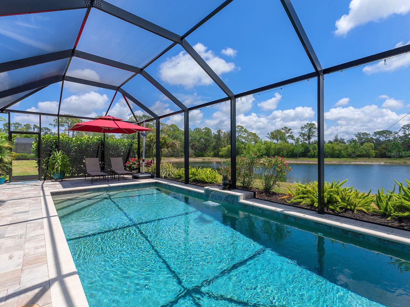 Enjoy morning light over the water, a peaceful poolside setting and extensive upgrades in this exceptionally well-maintained, turnkey-furnished home. This three-bedroom, three-bath home with a private den and two-car garage offers amazing views and improvements that set it apart. The east-facing backyard takes full advantage of the premium lakefront lot, with morning light and more comfortable afternoons around the private pool, installed in 2023, along with added privacy features for a more relaxed outdoor space. Inside, the home feels polished and move-in ready, with professionally painted interiors, crown molding, upgraded tile, plantation shutters and a layout that affords solitude to owners and guests. The den provides flexibility for a home office, guest space or additional sitting area, while the open kitchen offers plenty of granite countertop space, a closet pantry, Whirlpool appliances, double convection ovens, soft-close cabinets and slide-out storage features. Additional upgrades include custom cabinetry in the laundry room, upgraded lighting and decorative trim details that elevate the overall finish. Built for comfort and peace of mind, the home includes hurricane impact windows and doors, electric roll-down Kevlar hurricane screens for the lanai, a whole-house surge protector, leak detectors and a Carrier Infinity HVAC system with advanced multi-stage performance for more efficiency and ultra-quiet operation. Spray foam insulation creates a conditioned attic and contributes to improved energy efficiency, interior comfort and a cleaner living space. Additional features include an epoxy-coated garage floor, ceiling-mounted storage, plantation shutters, gutters, security cameras and a whole-house water softening system installed in 2025. Venice Woodlands offers a low-fee lifestyle with no CDD and a full amenity package including a community pool, clubhouse, fitness center, pickleball and bocce courts, along with lawn maintenance included for individual homes.