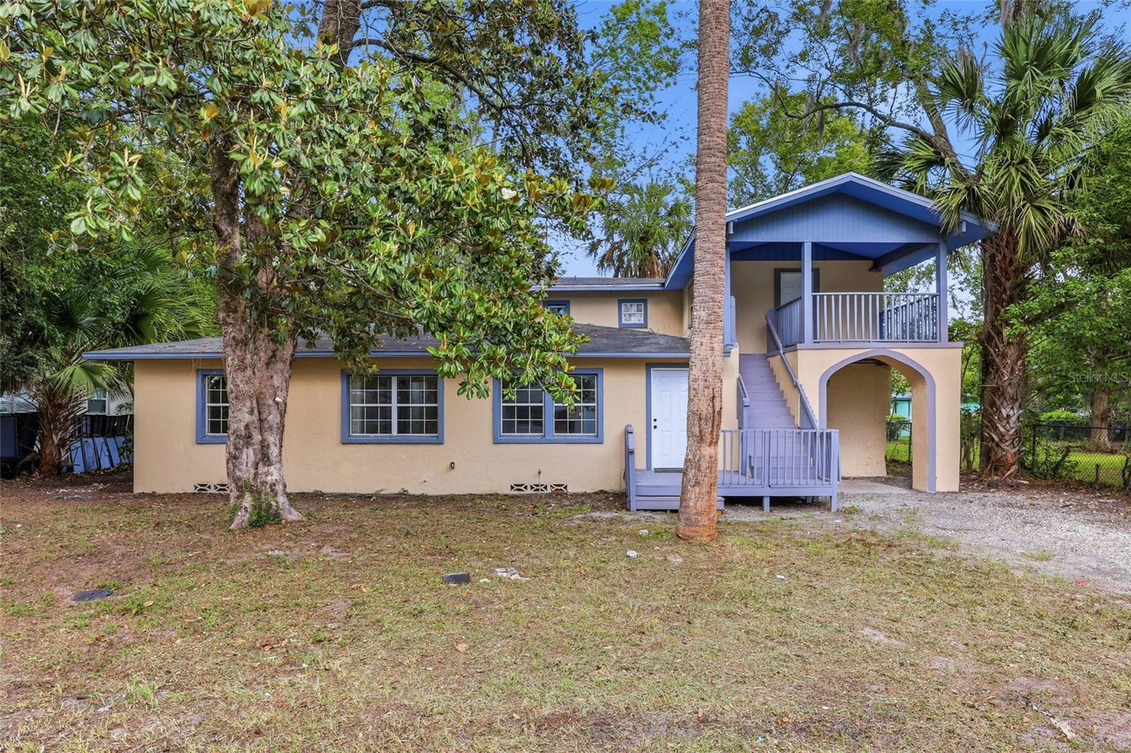 Spanning 2,263 heated square feet with 4 bedrooms and 2 baths on a 0.17-acre lot, this fully renovated Duval Heights home stands out for its unique architectural evolution, seamlessly blending original mid-century character with an expansive, multi-level modern footprint! The home features a complete top-to-bottom transformation highlighted by a brand-new roof, separate upper and lower AC units for zone-controlled comfort, fresh interior paint, and a striking contrast of dark wood-look vinyl plank flooring and pristine original stained hardwoods. Stepping indoors, the entryway opens into a classic front sitting room which transitions into an updated kitchen equipped with a center island, light cabinetry, granite-look countertops, and new stainless steel appliances. To the left of this main living hub, a hallway with original hardwood floors guides you to 3 comfortable main-floor bedrooms and a refreshed bath showcasing new cabinetry, an LED smart mirror, and large, textured marble-look tiles. To the right of the kitchen, the layout expands dramatically into a large living room bathed in natural light and featuring both front and rear exterior doors. The 2nd floor showcases a private bedroom with a large, covered balcony and a modern bath complete with a backlit mirror and custom-tiled shower. The rear exit on the main floor opens directly onto a concrete slab patio, a perfect setting for morning coffee or evening dining overlooking a backyard framed by mature, fruit-bearing passion fruit plants with plenty of space left over for a small pond or custom garden feature. Perfectly positioned for easy commuting and shopping, this property puts you just 2 miles from the Gainesville Shopping Center (featuring Publix), less than 3 miles from the heart of downtown Gainesville, and under 4 miles from both the Gainesville Regional Airport and the University of Florida campus. For outdoor recreation, you are incredibly close to local hotspots—located just 1 mile from Citizens Field and a short 3-mile drive to the Ironwood Golf Course, with North Central Florida’s world-famous natural springs located just a brief drive out of town. Reach out now to lock in your viewing time and find out how you can make this turnkey Duval Heights property your own!