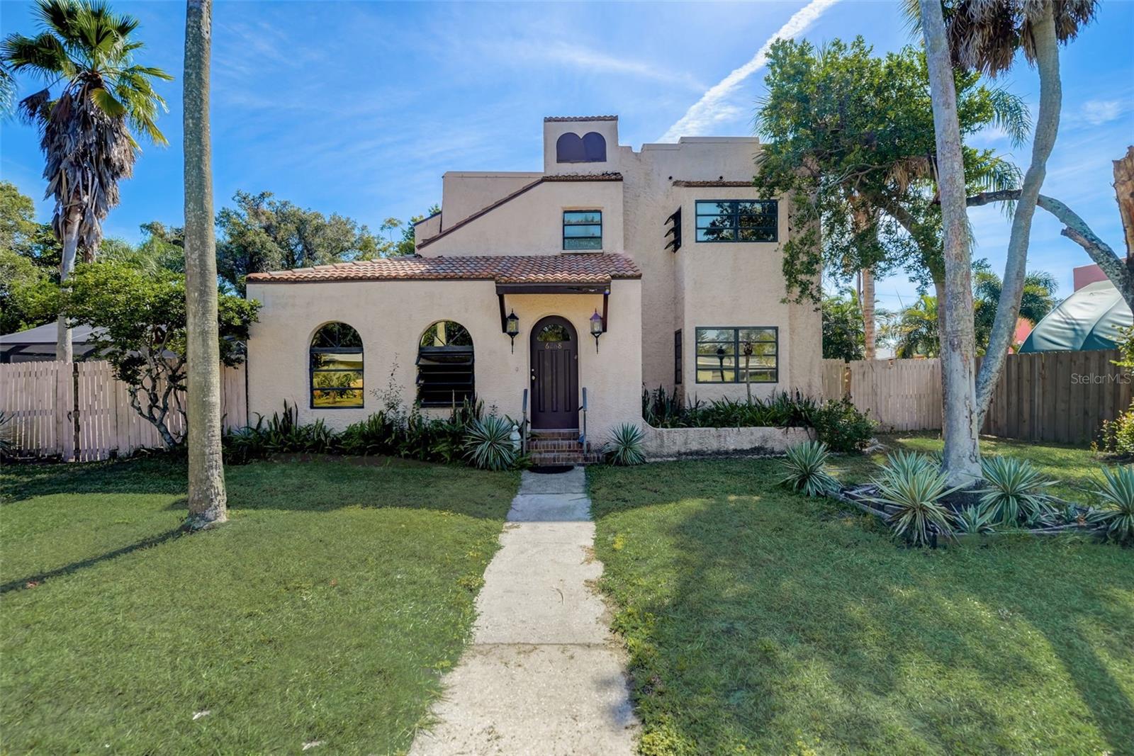Welcome to this spacious and elegant five-bedroom, four-bathroom home, spanning over 3,300 square feet. As you step inside, you'll immediately be captivated by the many details that adorn this beautiful residence. Each room is framed by arched doorways, setting the stage for the unique character of this home. Inside, you'll discover a harmonious blend of classic and contemporary elements. The pine wood flooring and large ceramic tiles throughout add warmth and charm, while the front living room's centerpiece is a cozy fireplace, perfect for creating a welcoming ambiance. For moments of quiet contemplation, the front living room also features a delightful window seat, providing the ideal spot to relax with a good book or enjoy the view. The separate formal dining room boasts a built-in glass shelf, making it an elegant space for hosting special occasions. The heart of the home is the large, open kitchen, a chef's dream with an abundance of beautiful wood cabinets and ample countertop space. A striking stained glass window nestled in the corner cabinetry adds a touch of artistry to this functional space. The breakfast bar and dining area off the kitchen, complete with a fireplace, offer the perfect setting for casual dining and entertaining. The living room boasts high ceilings and is flooded with natural light, thanks to the large sliding glass doors leading to the pool deck. Indoor/outdoor living is a breeze, and the pool deck becomes an extension of your living space, ideal for gatherings, relaxation, and soaking in the Florida sunshine. Each of the five bedrooms is generously proportioned, ensuring that everyone in the household enjoys their own private retreat.  Step outside, and you'll find a deck that's tailor-made for al fresco dining. Fire up the grill, entertain guests, or simply lounge around the screened-in pool. The fully fenced yard is a secure haven for your furry friends to run and play. This superb residence is ideally located, just a stone's throw away from Downtown Gulfport, renowned for its vibrant arts scene, local restaurants, and shopping. For those with a passion for golf and yachting, the Pasadena Golf & Yacht Club is within easy reach. And of course, the Gulf's shimmering waters are also close by, offering endless opportunities for outdoor adventures. Don't miss the chance to make this stunning home your own. Schedule a viewing today and experience the best of Florida living in this enchanting retreat!