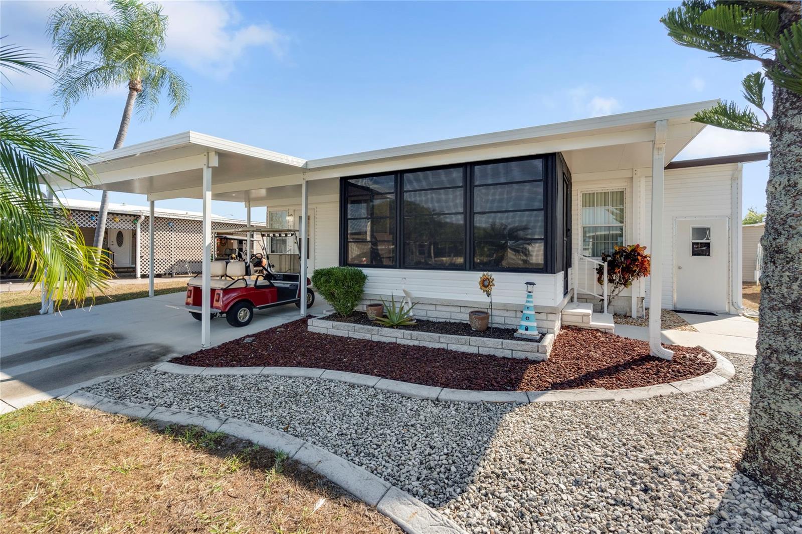 Welcome to Harbor Cove, an affordable, amenity-rich 55+ community along the Myakka River with Gulf access and a 90-slip marina. Residents here enjoy a vibrant lifestyle with a 17,000 sq ft clubhouse hosting dances, parties, picnics, talent shows, card games, and more with an HOA fee of only $175 per month. With a hint of Key West style, this nicely furnished 2-bedroom, 2-bath home features 972 sq ft of living space plus a 120 ft enclosed lanai. The large, updated kitchen with granite counters and newer appliances leads into a spacious living room with sliding doors to the lanai — perfect for morning coffee or afternoon gatherings with an extra fridge for food and beverages. The primary suite includes an updated bathroom and walk-in closet, while the guest bedroom is generously sized for visitors. Recent upgrades in the last 4 years include an AC unit and ductwork, hot water heater, washer and dryer, carport and lanai roofs, plumbing lines, and even a 50-inch TV. Plenty of dining options to choose from as meals can be enjoyed in the breakfast nook, kitchen dining space, or lanai. The included golf cart is parked under the carport for easy cruising down to the 2 swimming pools, spa, fitness center and various sports courts. A shed housing the washer and dryer provides a bit more storage space. Ideally located near Gulf beaches, dining, shopping, golf courses, spring training baseball parks, farmers markets, and quality medical services offering both recreation and convenience at your doorstep. Schedule a private tour today to see this charming residence!