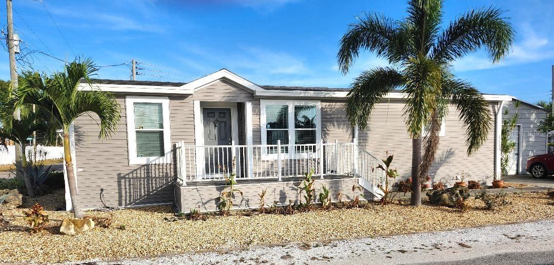 This 2018 Palm Harbor "VENTURA VI" model Double Wide manufactured home offers Three bedrooms and Two baths (1,432 sq ft), plus a detached 18'x20' double Garage in the highly desired, active 55+ Trailer Estates community. Buyers wait months for new models to be manufactured and installed, but you can MOVE right in! Located on a quiet street, you are greeted by a large front porch with notched entryway leading into bright, open-concept living and dining spaces. All drywall interior. Large kitchen island/breakfast bar. Primary Bedroom suite with roomy walk-in closet and dual sinks in the Primary ensuite Bath. The split floorplan provides two more Bedrooms and an additional Bath with plenty of room for guests. Separate Laundry Room just off kitchen with built-in shelving. A spacious rear deck is perfect for relaxing or entertaining. Lot is 6200+ sq ft with a single annual lot fee. No lot rent, you own the land. Park Fees are included into annual real estate taxes. Boaters have direct access to Sarasota Bay from the Marina. Trailer Estates community offers so many options for a great day! Enjoy the large, heated community pool, hot tub, gym and wood shop. The community buzzes with pickleball, shuffleboard, kayaking, horseshoes, bocce, dancing and more. A US Post Office on site. 10 minutes to the SRQ Airport. Convenient to shopping, restaurants, the Arts and everything in Bradenton/Sarasota. Sold unfurnished. Bring offers!