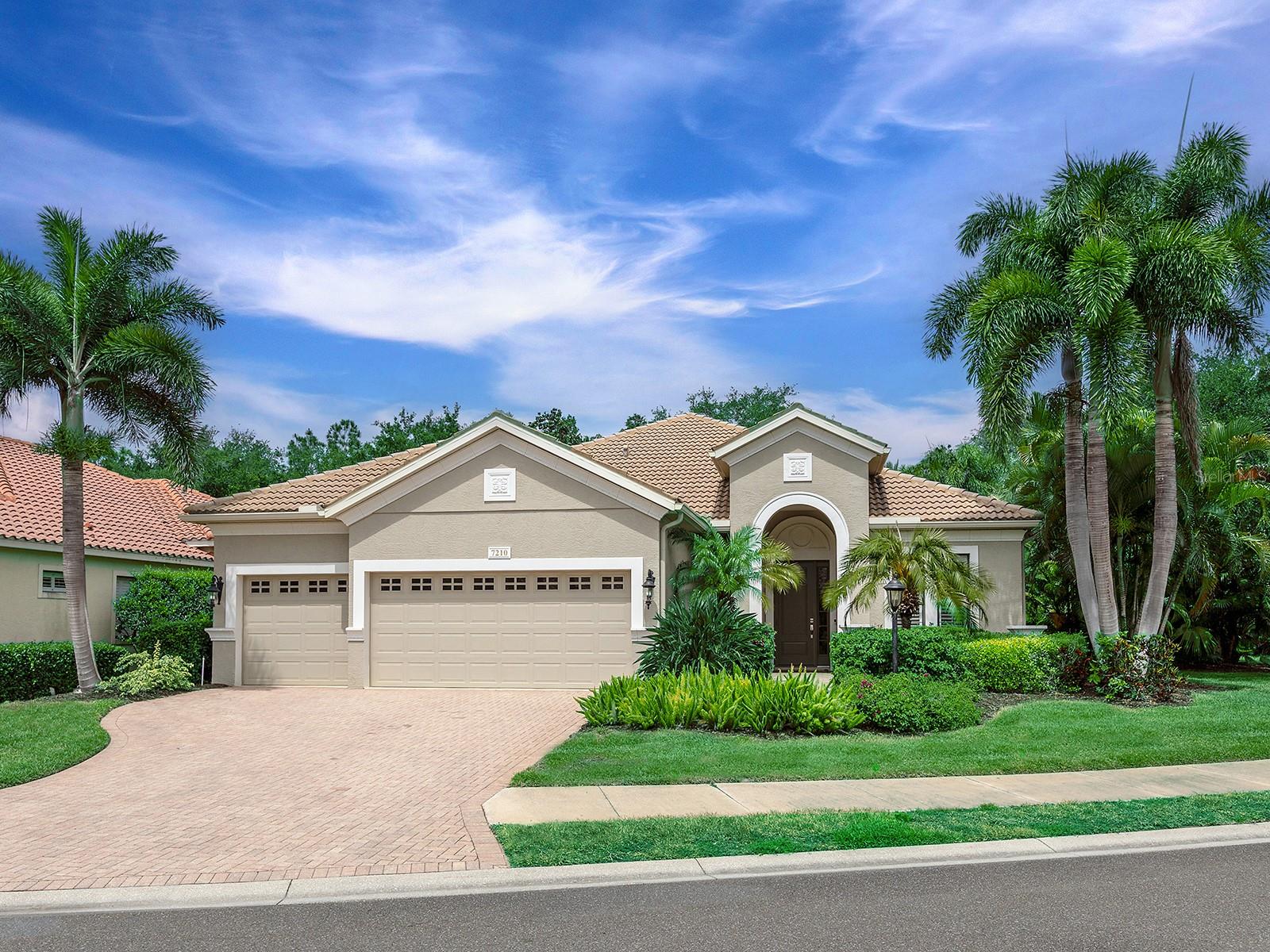 One or more photo(s) has been virtually staged. Welcome to 7210 Lake Forest Glen, where luxury, privacy, and beauty surround you in this exceptional maintenance-free home located in Lakewood Ranch Golf & Country Club. Perfectly situated on a private oversized cul-de-sac lot in Stone Ridge, this meticulously maintained Savona model by Neal, offers approximately 2,500 square feet with 3 bedrooms, 2.5 bathrooms, an office/den, and a 3-car garage.
This light-filled residence showcases 10-foot ceilings with elegant, coffered details, exceptional crown molding throughout, plantation shutters, and designer ceiling fans. Tile flooring runs throughout the home, including wood-look plank tile in the owner’s suite, office/den, and guest bedrooms.
A welcoming foyer opens to formal living and dining spaces, along with a private office/den featuring glass French doors—ideal for working from home or a quiet retreat. The open-concept floor plan is centered around a spacious family room with custom-built-ins and disappearing sliding glass doors that seamlessly blend indoor and outdoor living.
The beautifully appointed kitchen features cabinetry with glass-front upper doors, granite countertops, stainless steel appliances, a built-in desk area, breakfast bar, and casual dining space overlooking the family room.
The spacious owner’s retreat offers private lanai access, room for a sitting area, and a luxurious en-suite bath with dual vanities, soaking tub, walk-in shower, private water closet, and custom-designed walk-in closet with upgraded shelving and drawers.
Outdoor living is Exceptional with one of the largest lanai and lots in the neighborhood. The screened outdoor oasis features a resort-style pool and spa, lush tropical landscaping for added privacy, and a fully equipped outdoor kitchen complete with granite countertops, built-in refrigerator, gas grill, side burner, and sink. A generous covered entertaining area, cabana bath, outdoor shower, and gas fireplace complete this spectacular outdoor living space. You’ll love privacy as well as hosting guests and making wonderful memories in this outdoor oasis.
Living in Lakewood Ranch Golf & Country Club offers the opportunity to enjoy resort-style amenities with optional membership opportunities for golf, tennis, pickleball, fitness, dining, and social activities. Ideally located near world-class beaches, shopping, dining, and everything Lakewood Ranch has to offer.
A MUST SEE for buyers seeking a move-in ready home that blends luxury, privacy, and effortless Florida living.