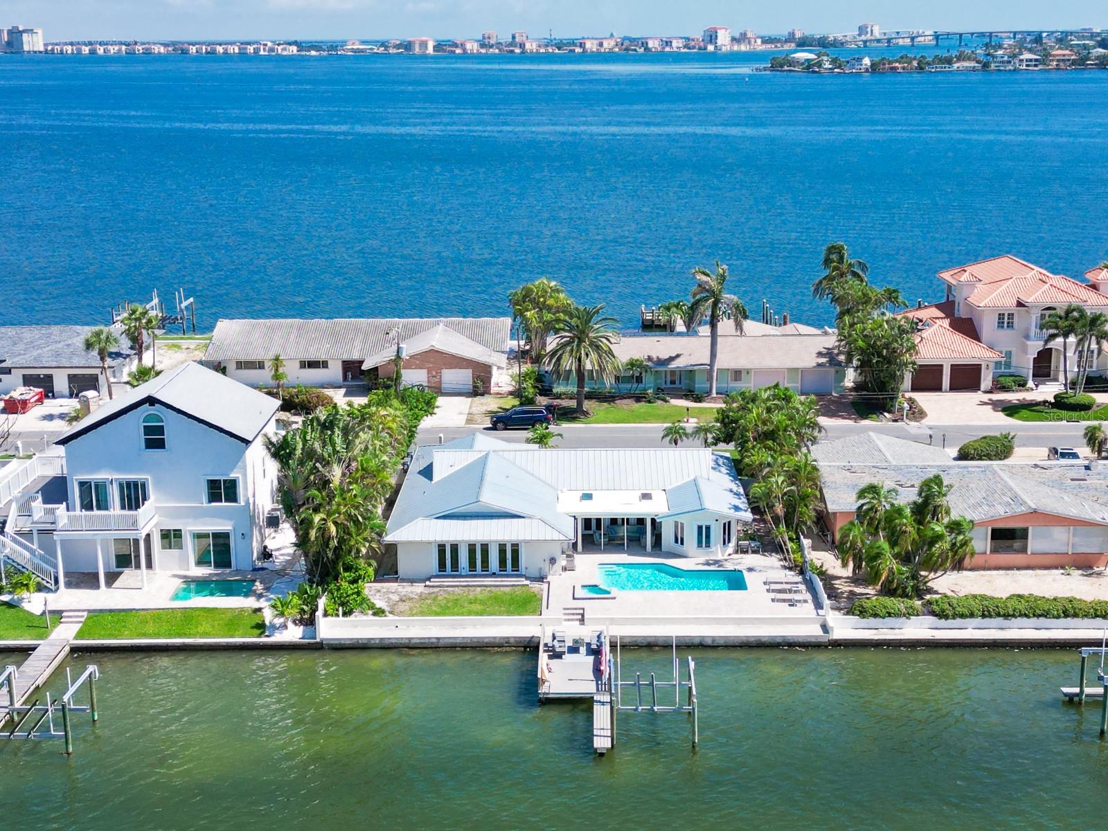 Experience the ultimate Florida waterfront lifestyle in your own private oasis on Boca Ciega Bay. Located in the prestigious Brightwater Beach Estates neighborhood of St. Pete Beach, this beautifully renovated and fully furnished 4-bedroom, 3-bath residence offers the perfect blend of luxury, comfort, and coastal elegance.

Designed for effortless indoor-outdoor living, the home features a bright open-concept layout, hurricane-rated windows and doors, modern European-inspired finishes, and a thoughtfully designed split-bedroom floor plan. The spacious primary suite serves as a peaceful retreat with tranquil bay window views, a cozy sitting area, and a spa-inspired en-suite bath complete with travertine tile, dual vanities, and a walk-in shower.

At the center of the home is a stunning custom chef’s kitchen featuring high-end stainless steel appliances, sleek contemporary cabinetry, wine cooler, warming drawer, walk-in pantry, and generous entertaining space ideal for hosting family and friends.

Step outside to your tropical waterfront retreat where a large pool, covered patio, dry bar, outdoor refrigerator, and designer furnishings create the perfect setting for year-round entertaining. Elegant French doors seamlessly blend indoor and outdoor living spaces, capturing the essence of relaxed coastal living.

Boating enthusiasts will appreciate the brand-new dock (2025) and 10,000-lb boat lift with direct access to the Intracoastal Waterway and the Gulf of Mexico — ideal for sunset cruises, waterfront dining, and days spent on the water.

Additional upgrades include a durable metal roof (2019), newer AC system, spacious indoor laundry room, and multiple living and entertaining areas throughout the home. Offered fully furnished, this exceptional property is ready for immediate enjoyment as a primary residence, vacation home, or luxury waterfront retreat.

Situated on a quiet low-traffic street with wide water views and just moments from the beach, restaurants, and vibrant downtown St. Petersburg, this home delivers the very best of the Florida lifestyle — sunshine, boating, breathtaking sunsets, and waterfront living at its finest.
