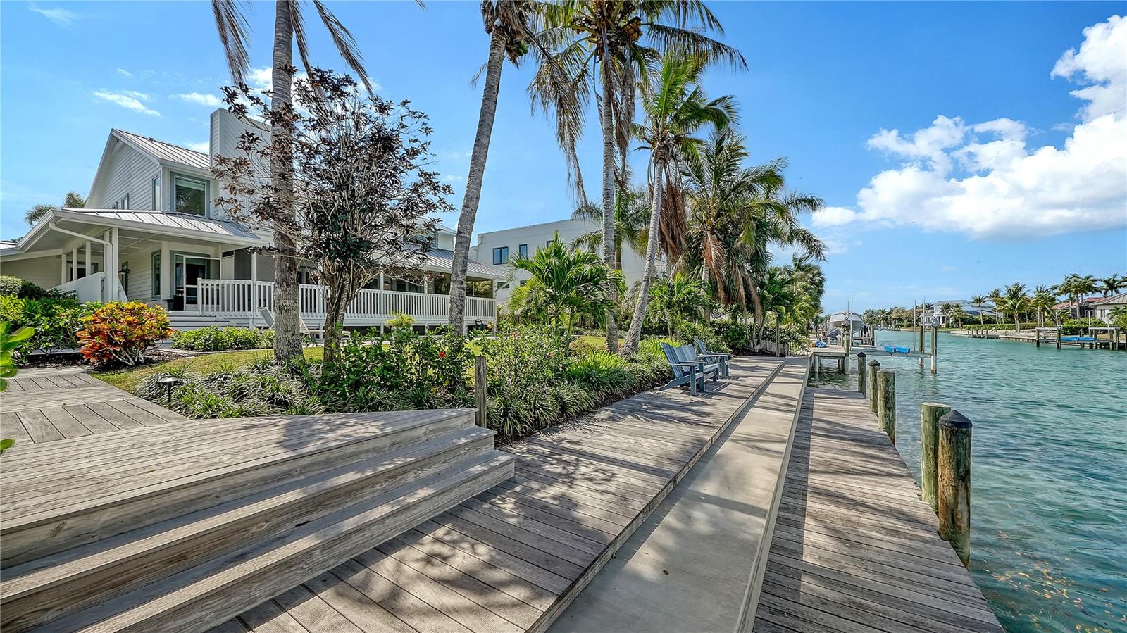 A Key West-inspired waterfront retreat in prestigious Bird Key, this residence blends timeless coastal design with extensive updates and exceptional indoor-outdoor living. Set along 101 feet of canal frontage with direct access to Sarasota Bay, the property offers a rare opportunity to enjoy a boating lifestyle in one of the area’s most sought-after neighborhoods.
Manicured landscaping and inviting front porches introduce the home’s architectural charm, while inside, nearly 3,400 square feet of living space unfolds across two levels (furnishings may be purchased separately). Beautiful hardwood flooring connects the open layout, where vaulted ceilings, skylights, and impact-rated PGT windows and doors fill the interiors with natural light. The double glass and solid wood entry opens to a bright, contemporary living space that flows effortlessly into the formal dining area.
At the heart of the home, the eat-in chef’s kitchen is thoughtfully designed with shaker-style cabinetry, quartz countertops, stainless steel appliances, a center island, and a breakfast bar peninsula. A dedicated cafe-style dining area is complemented by a wet bar featuring dual wine cooler/beverage refrigerator, and floating shelving. Impact sliding glass doors open to the covered outdoor entertaining area and pool deck beyond. This inviting space overlooks the family room.
Upstairs, the oversized primary suite offers a private retreat with terrace access, a spacious en-suite bathroom, and a walk-in closet. A second en-suite bedroom also enjoys its own terrace, while two additional guest bedrooms share a third bath, providing flexibility for family and visitors.
Outdoor living is designed for both relaxation and entertaining. The heated swimming pool is surrounded by a brick paver deck, with an additional open deck ideal for lounging. Just beyond, the extended dock and newly reinforced seawall (2025) create a seamless connection to the water, offering direct access to the waterway that flows out to Sarasota Bay, for boating and waterfront enjoyment. 
A long list of improvements enhances the home’s value and peace of mind, including a 2023 metal roof, impact PGT windows and doors, updated mechanical systems, and recent exterior upgrades such as new soffit, fascia, and gutters (2026).
Bird Key is known for its central location between downtown Sarasota and St. Armands Circle, offering residents convenient access to waterfront dining, boutique shopping, and cultural venues. Just minutes away, Lido Beach and Longboat Key provide some of the region’s most celebrated Gulf-front shorelines, while nearby marinas and yacht clubs complement the boating lifestyle that defines this exceptional community.
