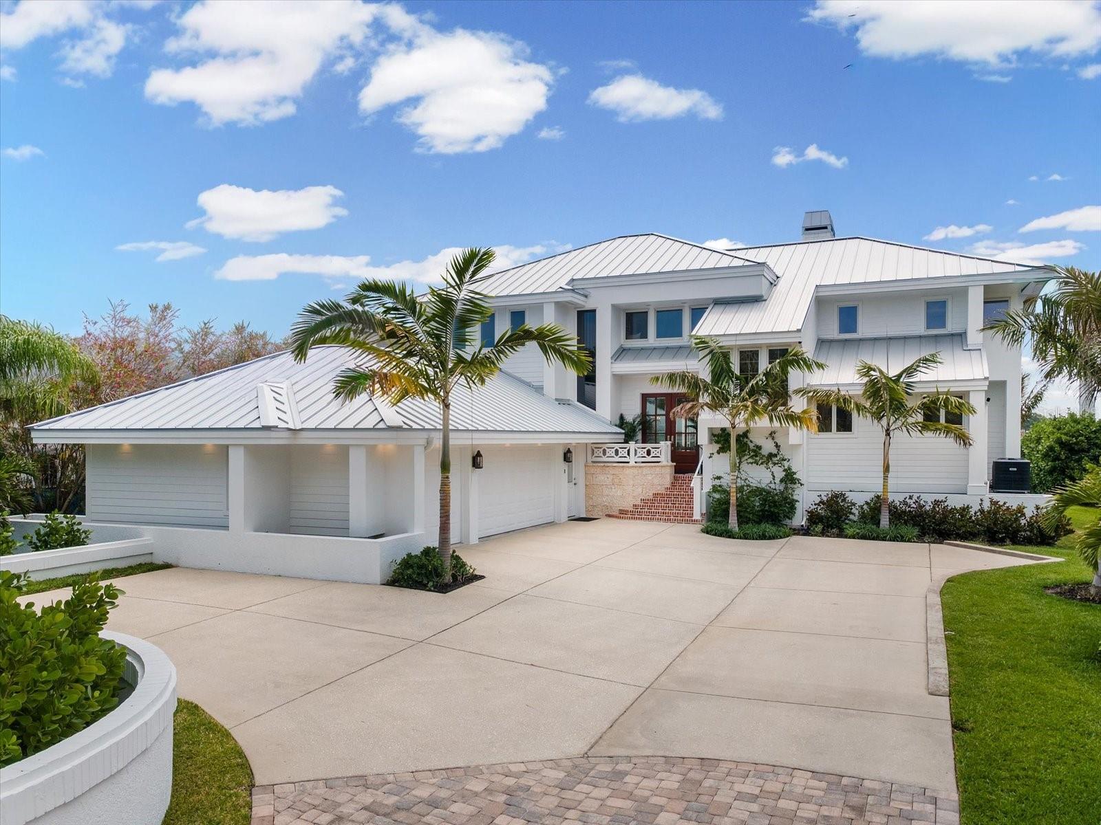 Virtually Staged. Welcome to an extraordinary waterfront estate in the exclusive gated enclave of Belleview Island — a completely reimagined luxury residence that underwent an extensive top-to-bottom renovation completed in 2025. Perfectly positioned on a sprawling half-acre homesite, this designer showcase captures serene water views stretching toward the world-famous Belleair Country Club West Course, where unforgettable sunrises become part of your daily routine. Featuring 4 bedrooms, 3.5 bathrooms, a 4-car garage, and a private elevator, every inch of this showcase home has been thoughtfully curated with designer finishes, custom millwork, white oak flooring, and furnishings and wallpaper by Schumacher and Serena & Lily. Upon entry, soaring ceilings and a stunning open great room with a beautiful gas fireplace create an impressive first impression. The first-floor primary retreat offers peaceful water views, impact glass sliders leading to the expansive patio, dual walk-in closets, and a spa-inspired en-suite with dual vanities, a jetted tub, and a walk-in shower. The chef’s kitchen is beautifully appointed with custom hardwood cabinetry, honed Carrara marble countertops, bar seating for four, high-end appliances including an ILVE Majestic induction range, integrated dishwasher, and ice maker. Adjacent to the kitchen, the formal dining area overlooks the screened patio, creating the perfect setting for morning coffee or evening wine by the water. Upstairs, three additional bedrooms provide exceptional flexibility, including a second primary suite with a private balcony overlooking the Intracoastal. A separate guest suite features its own private en-suite, while the fourth bedroom currently serves as a flex space. Current owners also have plans available for an addition over the garage that would add nearly 1,000 square feet of living space and an additional full bath. Designed for both comfort and entertaining, the home is equipped with built-in Sonos surround sound speakers throughout, while future plans for an infinity-edge pool provide the opportunity to complete the ultimate backyard oasis. Additional upgrades include a premier standing seam metal roof, tankless water heater, water filtration system, new ductwork, insulation, and more. Enjoy watching dolphins and local wildlife from the screened patio or your private dock equipped with a 16,000 lb lift offering quick access to the Intracoastal and Gulf waters. Belleview Island is renowned for its golf cart lifestyle and convenient access to Belleair Country Club, the premier club in the Tampa Bay area, featuring two championship golf courses, a state-of-the-art fitness center, tennis and pickleball courts, croquet, multiple dining venues, and more, all adjacent to the iconic Belleview Inn. Adding even more peace of mind, the home remained high and dry during recent storms and never lost power.