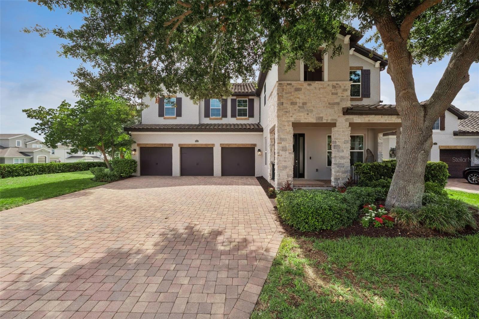 Five bedrooms, a three-car garage, soaring two-story ceilings, and paid off solar panels that make your electric bill make your jaw drop. Welcome to Twinwaters! This Meritage-built corner lot home has been freshly painted throughout the interior, fitted with brand-new carpet, and a new refrigerator. Just pack your bags. The layout delivers everything a house this size should: formal living and dining rooms connected through a butler's pantry with quartz countertops, a dedicated office, and an open kitchen and family room that flow together the way you actually live. The kitchen earns its place with a large island, 42-inch cabinetry, double ovens, stainless steel appliances, and more counter space than you will know what to do with. The custom built-in anchoring the family room is the kind of detail that photographs well and lives even better. The first-floor primary suite is spacious and private, with a massive walk-in closet with direct access from the laundry room, dual vanities, a freestanding soaking tub, and a walk-in shower with dual showerheads and floor-to-ceiling marble tile. Every bedroom in the house has a walk-in closet. Upstairs, a generous loft works perfectly as a second living room or playroom, and the two sets of bedrooms flank it on each side, each pair connected by its own jack-and-jill bath. The covered back patio with motorized screen is made for Florida evenings. Paid-off solar panels, blow-in attic insulation, and insulated block construction keep the utility bills remarkably low, month after month, and the tile roof adds long-term peace of mind. The THREE CAR GARAGE features an epoxied floor for a clean, finished look that goes well beyond the standard. Twinwaters has a community pool with splash features, two playgrounds, a park, and a trail through the conservation area, all nestled between Johns Lake and Lake Avalon. SR 429 and the Turnpike are minutes away. This home is conveniently located near Winter Garden Village, Plant Street, shopping, hospitals, Orlando's attractions and is zoned for some of the best schools in Orange County.
