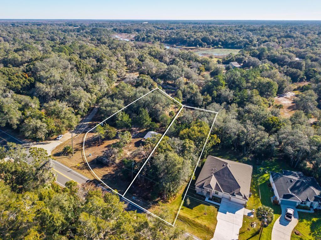 The price includes BOTH parcels: 2 PARCELS  next to each other (COUNTY ROAD 435, MOUNT PLYMOUTH,) Lots 23, 24, 25, 26, and 27, totaling nearly one acre. This rare offering provides the potential to build one large estate home or multiple smaller homes (buyer to verify with Lake County).
Situated on a prime corner location at Lochmore Circle and CR 435 with no rear neighbors, the property offers privacy, flexibility, and excellent access. A small vacant home currently sits on the property and may be rebuilt or removed.
A brand-new septic tank and drain field have been installed, adding immediate value and saving future development costs. Well is in place.
Located in the charming golf-cart community of Mount Plymouth in Sorrento, this area offers a peaceful country atmosphere while remaining convenient to everyday needs. IGA grocery and gas station are less than a quarter mile away. Just minutes to Mount Dora and the SR-429 entrance for easy commuting.
Exceptional land opportunity — make an offer today.