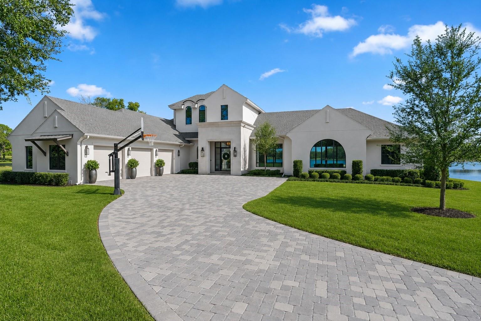 Experience an extraordinary waterfront estate on nearly 3 private acres with approximately 600 feet of lake frontage on beautiful Big Lake Mary. Completed in 2023 by renowned custom builder Dave Brewer Homes, this one-of-a-kind residence offers over 4,036 square feet of thoughtfully designed luxury living, blending timeless architecture with exceptional craftsmanship and modern amenities.

Privately gated and tucked away from the road, the property offers an unmatched level of privacy while showcasing breathtaking water views from nearly every room. Inside, you'll find 4 spacious bedrooms, a dedicated office, an expansive great room with a fireplace and surround sound—perfect for movie nights—plus a separate playroom/flex space. Walls of oversized windows fill the home with natural light while framing spectacular lake views.

The gourmet kitchen is designed for both everyday living and entertaining, featuring premium Thermador appliances, an oversized center island, custom cabinetry, and a generous walk-in pantry. Luxury finishes continue throughout with wide-plank wood flooring, custom built-in closets in every bedroom, designer lighting, and impeccable attention to detail.

The private primary suite is a true retreat with expansive lake views, a spacious custom walk-in closet, and a spa-inspired bath featuring a luxurious wet room with a freestanding soaking tub inside the oversized walk-in shower.

Outdoor living is equally impressive with a spacious covered lanai featuring a fully equipped summer kitchen, oversized entertaining island, screened saltwater pool and spa, and seamless indoor-outdoor living spaces designed to enjoy Florida's waterfront lifestyle year-round.

Boating enthusiasts will appreciate the private dock, private concrete boat ramp, and exceptional 600 feet of shoreline, providing rare access to Big Lake Mary. The beautifully landscaped grounds are enhanced with professional landscape lighting, creating a stunning setting both day and night.

Additional features include a 3-car garage plus dedicated rear golf cart garage, epoxy garage floors, an oversized laundry room with dual washers and dryers, utility sink, and abundant cabinetry, extensive storage including a large under-stair storage room, whole-home Sonos audio system with indoor and outdoor speakers, Sonos Amps for TV surround sound, security camera system, and countless high-end upgrades throughout.

Rarely does a property combine nearly three acres of privacy, new construction, extraordinary lake frontage, and luxury finishes in one of Lake Mary's most desirable locations. This is truly a once-in-a-generation opportunity to own one of the area's finest waterfront estates.