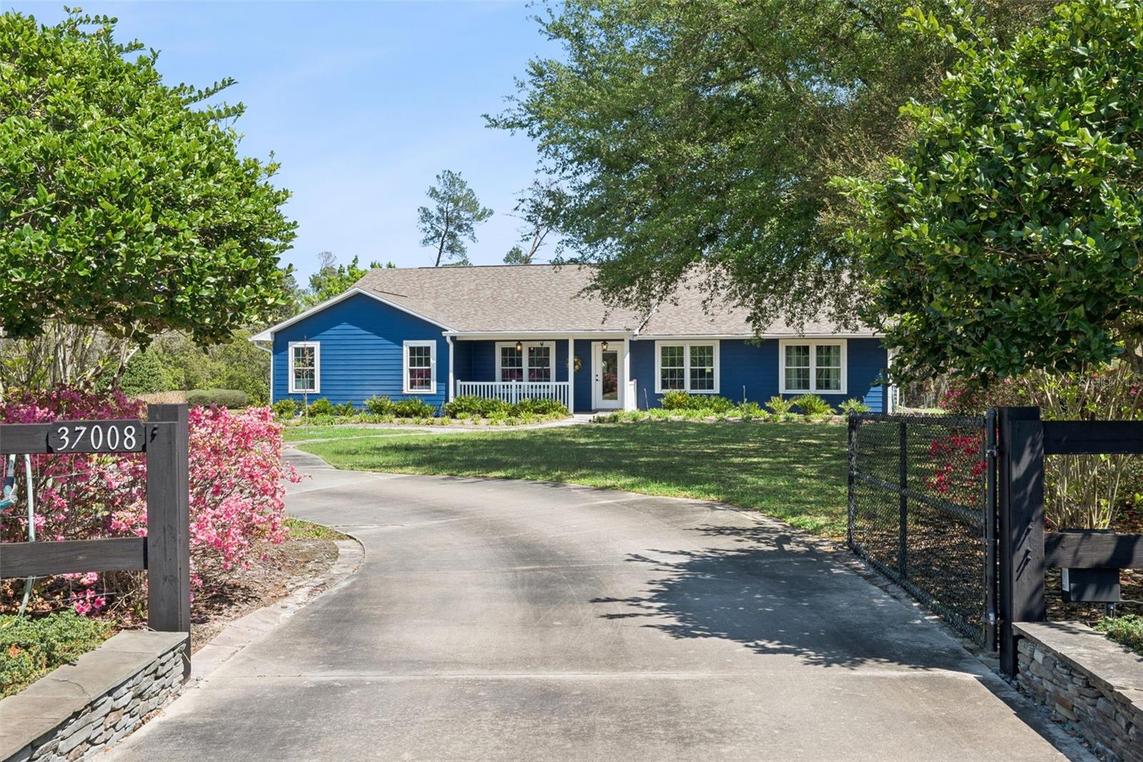 Welcome to this truly exceptional estate where thoughtful design, modern updates, and peaceful outdoor spaces come together perfectly. Tucked away on 2.24 beautifully landscaped, park-like acres in Eustis, this nearly 3,600-square-foot residence offers a rare mix of space, privacy, and quality renovations—all with a subtle country feel to welcome you home. 
Fully transformed in 2023, this home was redesigned and expanded, for both style and functionality. Inside, you’ll find an expansive-open concept layout highlighted by a stunning 900-square-foot great room that seamlessly combines the kitchen and living space—perfect for hosting friends and everyday living. Durable, wood-look tile runs throughout the entire home for a clean, cohesive foundation.
The brand-new kitchen is the heart of the home, featuring striking brick walls that add texture and charm. With updated 2023 appliances, a large prep island, and a walk-in pantry, it’s built for real life. Quartzite countertops offer a high-end finish that’s also durable and low-maintenance. The same quartzite surfaces flow from the kitchen into the fully renovated bathrooms, tying the design together seamlessly. You’ll also notice plenty of smart storage tucked away throughout the house to keep things organized.
A split floor plan ensures privacy, with three large bedrooms and three and a half bathrooms, all redone with beautiful materials and quality craftsmanship.  Additional living spaces include a dedicated office, dedicated dining area, and an inviting living room—offering flexibility for any lifestyle.
Step outside and experience your own private retreat. The grounds are meticulously maintained with lush landscaping, shaded walking paths and a peaceful, park-like setting that enhances the home’s quiet, country-inspired ambiance. A circular driveway provides ample parking and a great first impression.
Car enthusiasts, hobbyists, or business owners will appreciate the impressive 30x40 outbuilding, complete with electricity and space to accommodate up to eight vehicles—perfect for a workshop, storage, or garage use.
This home is as practical as it is beautiful, featuring major system upgrades including a 2021 roof, 2022 AC, two tankless water heaters, all-new PVC plumbing, and fresh interior and exterior paint completed in 2023. Every inch reflects pride of ownership and meticulous care.
A rare opportunity to own a fully renovated, move-in-ready estate with acreage, modern amenities, and timeless appeal—this property truly stands apart.