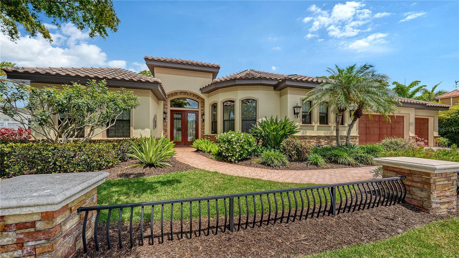 Perfectly positioned on one of Sarasota's most coveted West of Trail locations - the "Flower" streets - this custom built residence delivers a lifestyle that's walkable, central and effortlessly connected to everything Sarasota.  Just three blocks to Hillview's shopping, dining and Sarasota Memorial Hospital, a short stroll to top-rated Southside Elementary and only minutes to downtown Sarasota and world-renowned Siesta Key Beach - this is the epitome of "Location. Location. Location."  Built in 2011 by Paradise Homes, the home offers over 3,200 square feet of thoughtfully designed one-story living with 4 bedrooms and 3 baths. A bright, open-concept layout creates a natural flow for entertaining, while the split floor plan provides ideal privacy for guests or family. High-end finishes and custom details are found throughout—from tray ceilings and built-ins to designer closets and a warm gas fireplace anchoring the main living space.  The chef’s kitchen is both functional and refined, featuring stainless Viking appliances, granite countertops, custom cabinetry with glass accents, a walk-in pantry, and a reverse osmosis system with instant hot water—perfect for everyday living and hosting alike. Step outside to your pocketing sliding doors  to a shaded, private Florida retreat - where a saltwater PebbleTec pool and spa, pavered pool deck, and fire pit set the tone for relaxed coastal living. The fully equipped outdoor kitchen—complete with grill, sink, and refrigerator—makes entertaining a breeze, all complemented by a charming side garden for added privacy and ambiance.  Constructed with concrete block and outfitted with all impact-rated windows and doors plus electronic shutters - the home offers exceptional peace of mind. Modern conveniences include a Control4 smart home system and a new (2025) tankless water heater. An oversized three-car garage with epoxy flooring, irrigation well, and meticulous attention to detail complete the offering.