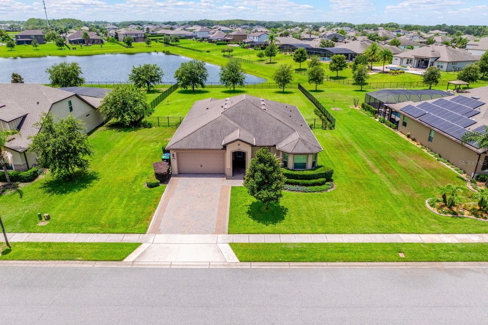 Virtually Staged. Welcome to Estates at Lake Pickett, a GATED COMMUNITY in East Orlando built around one of Central Florida's PREMIER SKI LAKES. This MOVE-IN READY single-story estate home offers 3 BEDROOMS PLUS a private office/den behind glass French doors that easily works as a 4TH BEDROOM, 2.5 baths, and over 2,400 SQUARE FEET on a HALF ACRE with peaceful pond views. Built in 2018, it still FEELS LIKE NEW and comes with a 3-CAR GARAGE, brick paver driveway, and countless upgrades throughout. Out front, lush landscaping and an etched glass front door give this home IMPRESSIVE CURB APPEAL. Wi-Fi ENABLED exterior lighting with COLOR-CHANGING LED ACCENTS lets you set the mood for any season or occasion. Inside, an open floor plan and expansive windows fill the home with NATURAL LIGHT and frame the pond views from the Living Room, Dining area, and Kitchen. The GOURMET KITCHEN is the heart of the home, featuring an abundance of 42-inch cabinetry, GRANITE COUNTERTOPS, built-in ovens, a cooktop, a large breakfast bar, and a walk-in closet pantry. Just off the Kitchen sits a VERSATILE SPACE that works as a butler's pantry, coffee bar, homework station, or drop-in office. Sliding glass doors off the Dining area open to a COVERED, SCREENED PAVER LANAI overlooking the OVERSIZED BACKYARD, fully enclosed with elegant aluminum fencing and backing to a quiet pond, with plenty of room to entertain, play, or add a pool. A MUDROOM/DROP ZONE off the garage keeps everyday life organized, and the dedicated Laundry Room includes the washer, dryer, and built-in shelving. Thanks to the SPLIT BEDROOM layout, the private PRIMARY SUITE sits on its own for maximum privacy, a true retreat with a spacious walk-in closet and a SPA-INSPIRED EN SUITE featuring dual vanities, an oversized walk-in shower with built-in bench seating, and a private water closet. Two additional bedrooms sit near a full bath, while the private OFFICE gives you the flexibility of a 4TH BEDROOM, playroom, or hobby room. One of the community's most SOUGHT-AFTER FEATURES is its PRIVATE COMMUNITY BOAT RAMP, dock, and direct access to LAKE PICKETT. Boat, fish, paddleboard, or simply spend the evening on the water. You are minutes from the UNIVERSITY OF CENTRAL FLORIDA, Waterford Lakes Town Center, and the shopping and dining of Oviedo and Lake Nona. Nearby HAL SCOTT REGIONAL PRESERVE offers miles of hiking, biking, and horseback riding trails, and SR 417 and SR 408 make for an EASY COMMUTE to Downtown Orlando, Orlando International Airport, and Central Florida's WORLD-FAMOUS ATTRACTIONS. With luxury finishes, an INCREDIBLE HOMESITE, rare lake access, and resort-style outdoor living, this one checks every box. Schedule your private tour today!