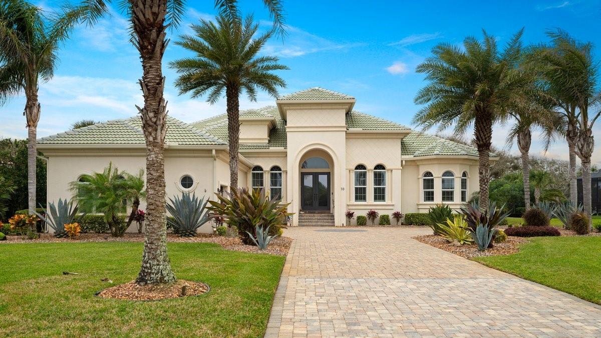 SELLER IS OPEN TO SELLING WITH MOST FURNITURE INCLUDED! This stunning Coastal West Indies-inspired estate home in the prestigious Granada Estates of Hammock Dunes, Palm Coast, Florida, perfectly blends timeless elegance with tropical practicality. Nestled on a private ½-acre waterfront and wooded homesite, this 5-bedroom, 6.5-bathroom residence (with multiple en suites) was meticulously remodeled in 2019 and remains in pristine condition.
The main living areas feature durable, waterproof luxury vinyl flooring, ideal for Florida's coastal lifestyle. The designer's chef's kitchen opens seamlessly for entertaining, flowing into a family room with a sleek electric linear fireplace mantle.
Every main living space offers breathtaking views of the expansive pool area and lush estate grounds. Enjoy seamless indoor-outdoor flow through 90-degree sliding glass doors in the family room and upstairs bonus room. The owners' suite provides serene poolside views and leads to a spa-inspired bathroom with elegant marble floors.
Upstairs, an expansive wrap-around veranda enhances the home's architectural charm and natural textures. Outdoors, the resort-style amenities shine: a heated swimming pool and spa, summer kitchen, covered living spaces with multiple sunbathing areas, and an open paver patio perfect for relaxation.
Additional highlights include a three-car garage, expanded driveway, luxurious landscaping with lighting, and a Generac home generator for peace of mind. The property is walking distance to the community beach walkover, offering easy access to the pristine Atlantic.
Hammock Dunes is a private, gated oceanfront golf community with optional club membership featuring two championship courses, tennis, pickleball, fitness center, oceanfront dining, and more. You're also close to Flagler Beach, Hammock, and St. Augustine for dining, shopping, and attractions.
This home embodies sophisticated coastal living in one of Palm Coast's most exclusive neighborhoods—ideal for those seeking luxury, privacy, and Florida's natural beauty! If this matches a property you're considering or listing, it's a true gem.