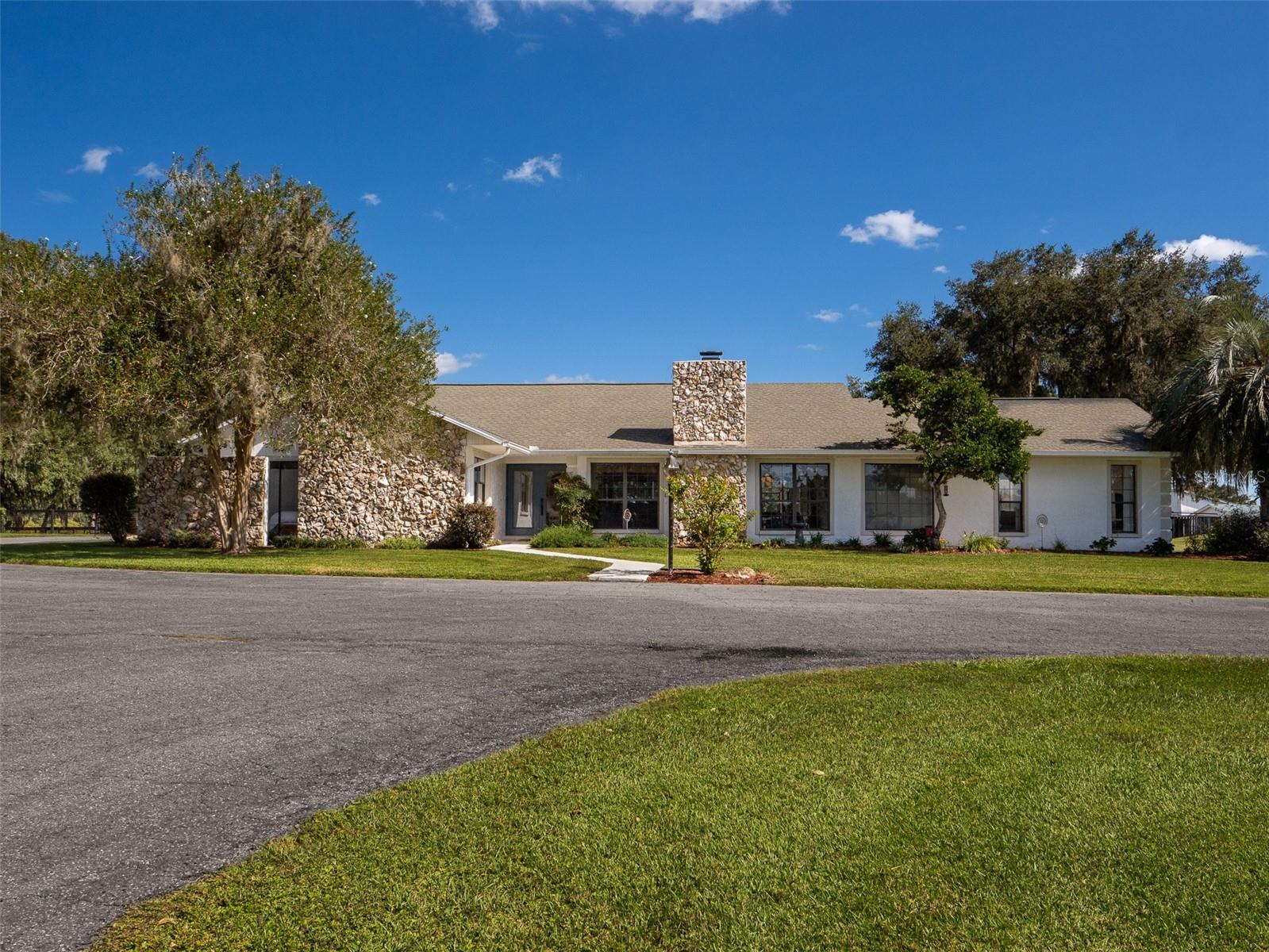Located just 20 minutes from the World Equestrian Center, this exceptional 20-acre horse farm offers top-tier equestrian amenities paired with beautiful residential living. The property features a 9-stall concrete block center-aisle barn with 12x12 stalls, including a foaling stall, premium Stable Comfort mats, fans, and a fly spray system. Additional barn features include a hot/cold water wash stall, bathroom, tack and feed rooms, and a eurociser. A separate stallion barn offers two large stalls along with a three-bay workshop for equipment storage and added functionality. Expansive pastures with freshly painted fencing and landscaped grounds surround the farm, creating a serene and scenic setting.
The custom-built, block 3-bedroom, 2-bathroom home sits at the heart of the property and features a fully renovated 2026 kitchen with all-new appliances, new flooring throughout the home, and updated modern LED lighting. The open floor plan offers soaring ceilings and a spacious great room with a cozy fireplace, while oversized windows provide panoramic pasture views and abundant natural light. A charming 1-bedroom, 1-bathroom block guest house completes the property, offering a kitchenette, laundry room, and large closet—ideal for guests or farm staff. This farm presents a rare opportunity to enjoy refined rural living with professional-grade equestrian facilities in a prime Central Florida location.