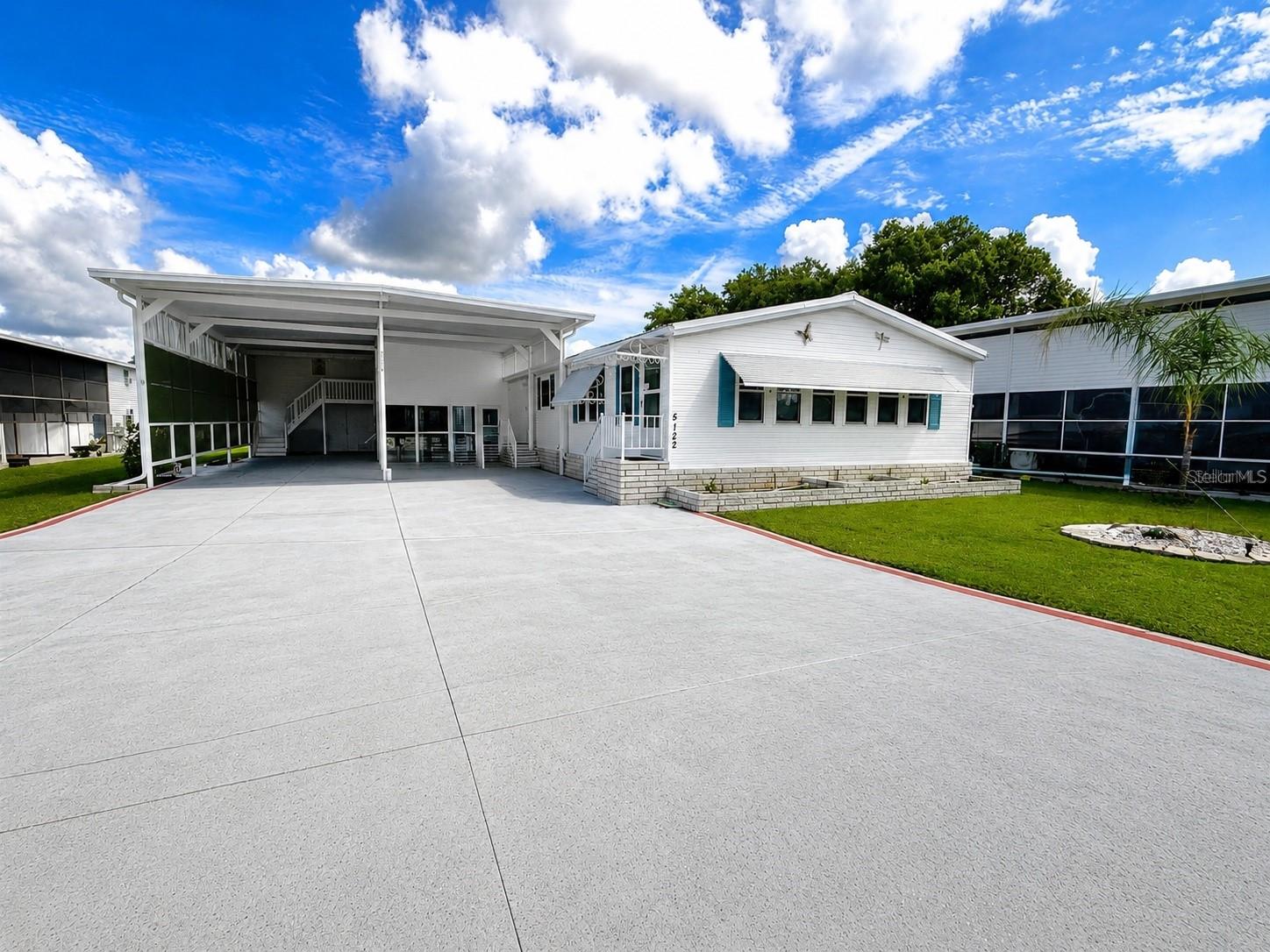 Welcome to the lifestyle you’ve been waiting for in the highly desirable, gated community of Mount Olive Shores. This beautifully maintained, fully furnished Palm Harbor RV Port Home delivers the ideal combination of space, structural confidence, and true turnkey convenience — allowing you to arrive and immediately begin enjoying the Class A motorcoach lifestyle.

Positioned on an expansive lot and a half and securely anchored to a solid concrete slab, this property offers both presence and peace of mind. A brand-new, weather-resistant metal roof is currently being installed, and the plumbing system has been fully upgraded to modern standards. An Engineer’s Foundation Certification Letter will be provided, further validating the home’s structural integrity — a valuable and uncommon assurance.

Designed specifically for the Class A enthusiast, the oversized RV port easily accommodates large motorhomes with slides extended and includes a convenient carport. There is ample space to maneuver, entertain, and fully enjoy your investment. Beneath the carport, you’ll find an attached bonus room of over 300 square feet — ideal for a private office, media lounge, hobby room, or guest retreat. A separate, generously sized workshop with second-floor storage adds significant flexibility, offering dedicated space for tools, projects, and additional storage without compromising living comfort.

Life at Mount Olive Shores extends well beyond the property itself. The community now features a brand-new 5,000-square-foot heated and cooled Community Center designed to elevate the resident experience. Amenities include a full kitchen, regulation-size shuffleboard and pool tables, dart board, arcade games, a dedicated card room, library, vending area, and a covered BBQ lanai perfect for gatherings. A vibrant calendar of seasonal activities — including Bingo, karaoke nights, potluck dinners, holiday celebrations, and numerous social events — creates consistent opportunities for connection and recreation.

Conveniently located just 3.5 miles from I-4, residents enjoy quick access to shopping, dining, premier medical facilities, Tampa and Orlando International Airports, and Central Florida’s world-renowned attractions — all within approximately one hour.

Please note: ownership or lease of a Class A motorhome is required your first year of residency.

Fully furnished, structurally certified, thoughtfully upgraded, and situated on an oversized lot — opportunities of this caliber are limited. Schedule your private showing and take the next decisive step toward the motorcoach lifestyle you’ve earned.