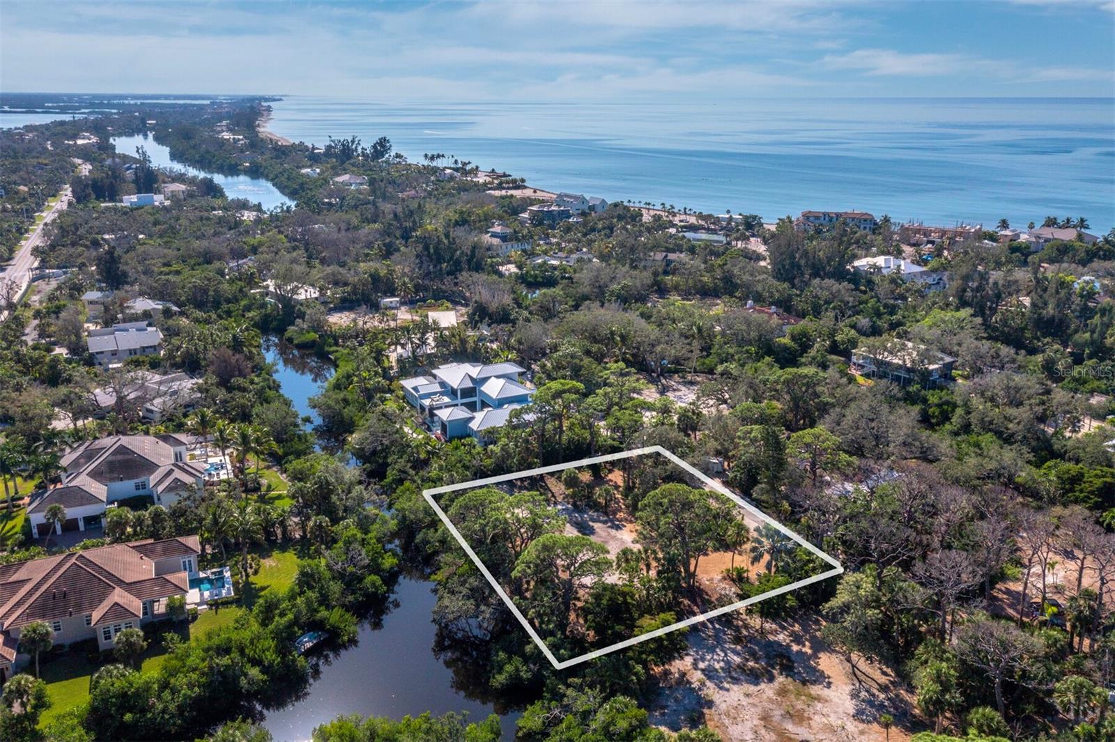 Located behind the gates of The Sanderling Club on a private canopied lane, this special property features access to a breathtaking private beach and private marina. It is a rare opportunity to build a signature residence on one of the most picturesque parcels in the exclusive Sanderling Club on Siesta Key. This .73-acre homesite is tucked away on a quiet, canopy-lined lane, surrounded by mature tropical forest and majestic Live Oaks, offering unmatched tranquility and privacy. The entire eastern boundary of the property fronts the freshest waters of Heron Lagoon—directly across from the Sarasota Bay inlet—providing expansive, ever-changing views of this tidal sanctuary. Paddleboard, kayak, or simply relax as wildlife glides past your future backyard oasis. With all utilities in place and access to a private well for irrigation, this lot is cleared and ready for your dream estate. Just a short walk away, enjoy the powdery quartz sands of Siesta Key Beach and the Sanderling Club’s private Gulf-front beach, where members gather for sunset strolls and sightings of the elusive “green flash.” The community offers 24-hour attended gate security, a historic Paul Rudolph-designed clubhouse, tennis and pickleball courts, and a private marina with direct access to Sarasota Bay and the Gulf via the newly reopened Midnight Pass. The Sanderling Club is truly unique on the key, featuring an Old-Florida feel with meandering roads lined with mature trees, plus amenities that are simply unrivaled. Whether you envision a modern coastal retreat or a timeless island compound, this property offers the perfect canvas in one of Florida’s most prestigious beachfront communities with privacy, beach life and easy access to Siesta Key Village and Sarasota’s vibrant arts and dining scene.
