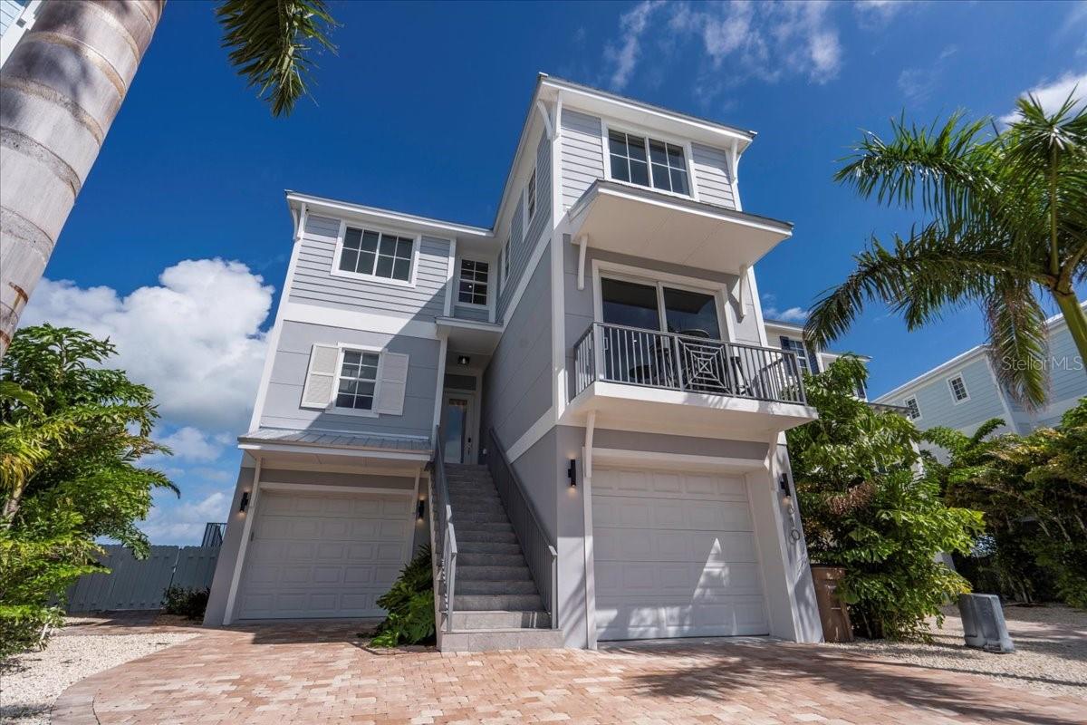 Welcome to 810 39th Street Gulf, a stunning new 2024 Gulf-front home in Emerald Flats, an exclusive gated community of just 18 residences. Built by the Keys' premier builder D'Asign Source, this three-story concrete block home with concrete subfloors combines strength, design, and luxury in every detail. Featuring 5 bedrooms and 5 baths, this residence offers a bright open layout with panoramic Gulf views through walls of glass. The private elevator connects all levels, and the interior showcases a chef's kitchen with premium appliances, quartz counters, and a full wet bar for effortless entertaining. The outdoor space is pure paradise with a resort-style pool, hot tub, and sunshelf, all positioned perfectly to enjoy both sunrises and sunsets from the home's ideal north-facing exposure. Boaters will love the private 50' boat slip with deep-water access, plus additional slips available if needed. The expansive garage and tackle area provides ample storage and includes an industrial refrigerator and freezer, ideal for fishing and boating enthusiasts. The home also offers three washers and three dryers, lockable owner's closets, and a proven record as a profitable vacation rental, with future bookings that can be retained or released by the buyer. Designed and built for low-maintenance, luxury coastal living, this home combines elegant finishes, enduring construction, and unmatched functionality. Whether as a primary residence, family retreat, or high-performing investment, 810 39th Street Gulf delivers the ultimate Florida Keys lifestyle—new construction, deep-water access, and breathtaking open-water views in one of Marathon's most desirable Gulf-front settings.