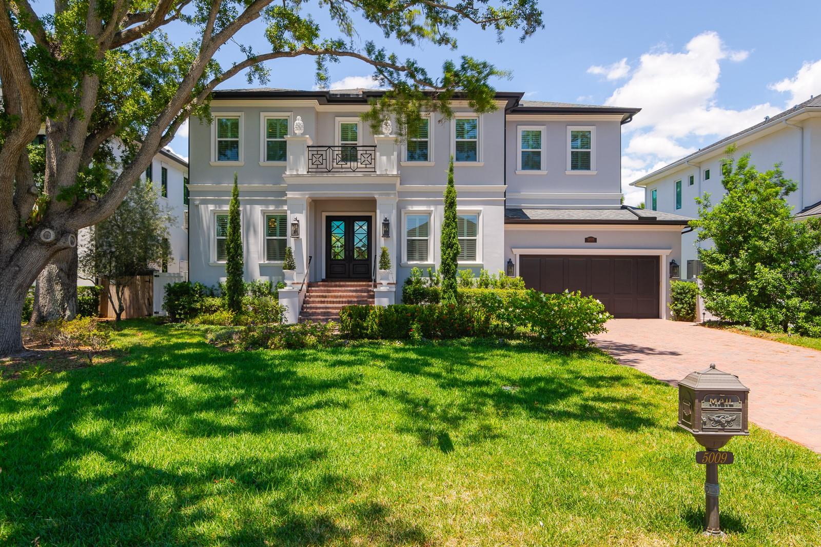 Price reduced $100k on this Custom build 2023 by Sample Properties, this exceptional luxury residence is located in coveted Sunset Park, one of South Tampa’s most desirable neighborhoods, known for its established streetscape, custom homes, and convenient access to premier shopping, dining, Tampa International Airport, and the city’s business districts. A statement glass entry door opens to a gracious foyer framed by a formal dining room and an elegant living room with built-in bookshelves and crystal chandeliers, while the home itself pairs timeless design with the elevated indoor-outdoor lifestyle Tampa buyers are seeking. The spacious family room is designed for both everyday comfort and entertaining, featuring a gas fireplace, built-in shelving, box-beam ceilings, and crown molding. At the heart of the home, the gourmet kitchen offers a large center island, Wolf cooking appliances, Sub-Zero refrigeration, and custom cabinetry. The adjoining walk-in butler’s pantry is exceptionally well equipped with an additional refrigerator, dishwasher, and Scotsman ice maker for effortless entertaining. Wood flooring throughout the first level adds warmth, continuity, and classic appeal. A first-floor guest suite with a private en-suite bath provides ideal accommodations for visitors or multigenerational living. Outside, a covered lanai with an outdoor kitchen and grill creates a true Florida retreat, ideal for year-round dining and relaxation. The resort-style pool showcases a sun shelf, dual fire features, and a spa, bringing a refined sense of luxury to the backyard experience. The primary suite offers wood flooring, a generous walk-in closet, and a beautifully appointed bath with marble floors, a soaking tub, and an oversized shower with built-in bench seating. Additional bedrooms each include walk-in closets and en-suite baths, while one bedroom is enhanced by a kitchenette and beverage refrigerator. A generously sized laundry room with abundant cabinetry and counter space adds everyday convenience. Built with two-story all-block construction and equipped with a natural gas whole-house generator, the home offers lasting quality and added peace of mind. Thoughtfully designed landscape lighting completes the property with a polished, upscale finish.