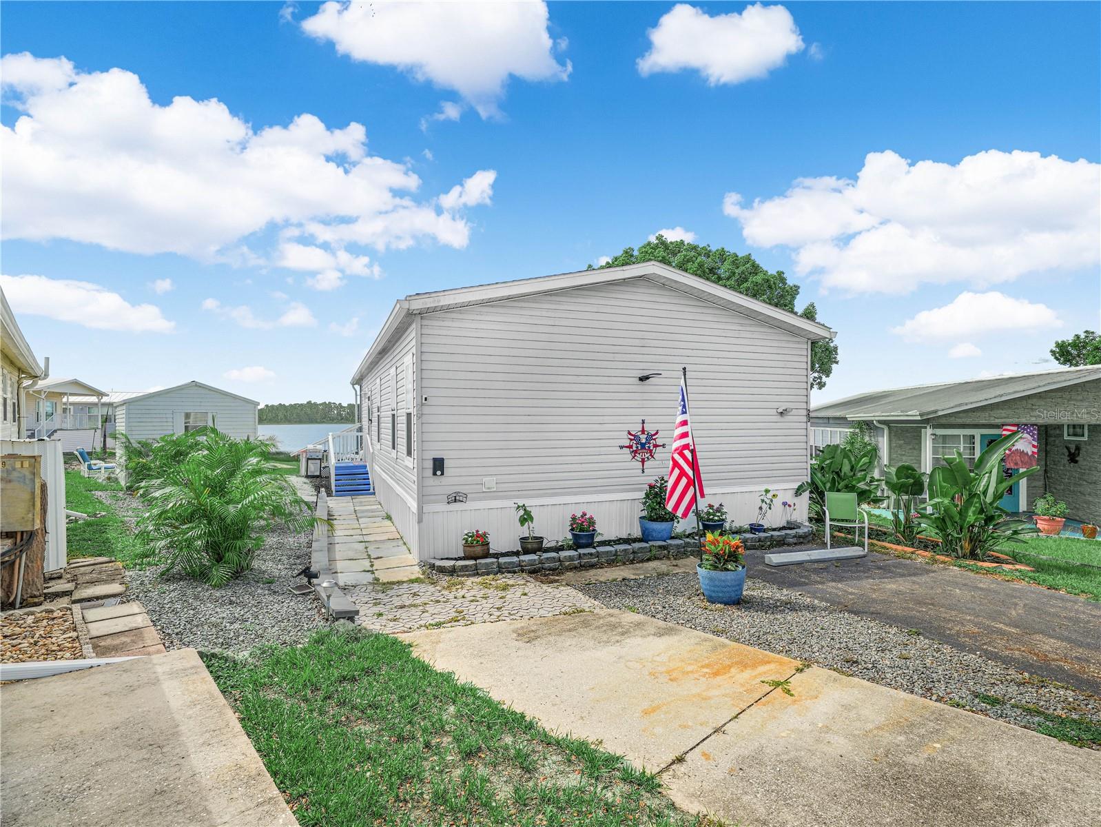 This 2/2 LAKE SIDE Jacobsen manufactured home is located in the 55+ pet friendly, gated community of Saddlebag Lake Resort and comes fully furnished and turnkey.  You'll love the stunning view of the lake from the full-width screened porch, and even from the main inside living space. The home was custom built with lots of premium upgrades, including luxury laminate flooring throughout, dolomite stone counter tops in the kitchen as well as both bathrooms, 9 ft. high ceilings and stainless steel appliances.  The gourmet kitchen has a large island with bar stools, and plenty of cabinets so there's a place for everything.  The owner's suite has a HUGE ensuite bathroom that features a relaxing spa.  When you're ready to venture out, you can enjoy as active a lifestyle as you want.  There's a crystal clear community pool, a hot tub, tennis, pickle ball and shuffleboard courts, horse shoes, a fitness center, a rec room with pool tables and saunas, a driving range, and a beach house that you can reserve at no cost for private events.  Get to know your neighbors at the clubhouse and participate in planned activities, or join the club of your choice.  There's a post office onsite, you don't even have to leave the resort to get your mail.   Isn't it time you came home to Saddlebag Lake Resort?  Call now to schedule your private tour and start living the good life today!