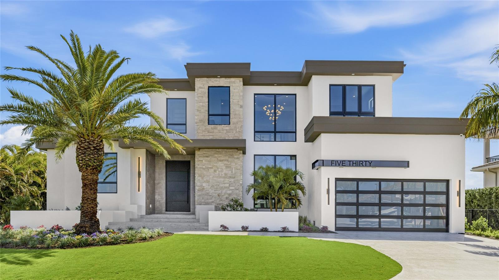 Introducing the newest custom residence by Brista Homes, where exceptional craftsmanship and thoughtful design come together in a limited and highly refined offering. Nestled along a quiet canal in the sought-after waterfront community of Country Club Shores, this 4216 square-foot residence captures the essence of the Longboat Key boating lifestyle. With desirable south-facing rear exposure, tranquil canal views create a peaceful backdrop to daily living, while upper balconies frame beautiful views of Sarasota Bay. The home’s architecture, floor plan, and interior selections were curated by Brista’s in-house design team, drawing on years of experience building on Longboat Key and a deep understanding of what today’s waterfront buyers value most—timeless architecture, premium materials, and seamless indoor-outdoor living. A handcrafted iron pivot entry door framed by natural stone detailing creates a striking first impression. Inside, pocketing glass doors open the main living spaces to a resort-style outdoor setting where a custom salt water pool and elevated heated spa are surrounded by porcelain pavers and lush coastal landscaping. A fully equipped outdoor kitchen creates the ideal setting for entertaining along the water. At the heart of the home, the kitchen blends refined design with exceptional functionality. Custom Italian cabinetry is complemented by a dramatic Quartzite waterfall island and matching hood feature. A premium appliance suite by Miele — including a built-in refrigerator, integrated dishwashers, speed oven, and built in coffee maker — is complemented with a striking 48-inch dual-fuel range. A hidden butler’s pantry and custom wine display add both style and practicality for effortless entertaining. The great room centers around a sleek linear fireplace, creating a sophisticated gathering space. Upstairs, a spacious club room with a media wall and wet bar offers a relaxed setting for evenings with family and guests. Architectural details throughout the home include white oak plank flooring, a dramatic floating staircase, recessed baseboards, and clean modern lines that reflect a refined coastal aesthetic. Modern conveniences include whole-home audio, a whole house generator, multi-zone climate control, and integrated security. Located within one of Longboat Key’s most desirable boating communities, where deepwater canals provide quick access to Sarasota Bay and the Gulf of Mexico, this newly completed custom residence represents a rare opportunity to experience waterfront living defined by thoughtful design, exceptional craftsmanship, and enduring quality.