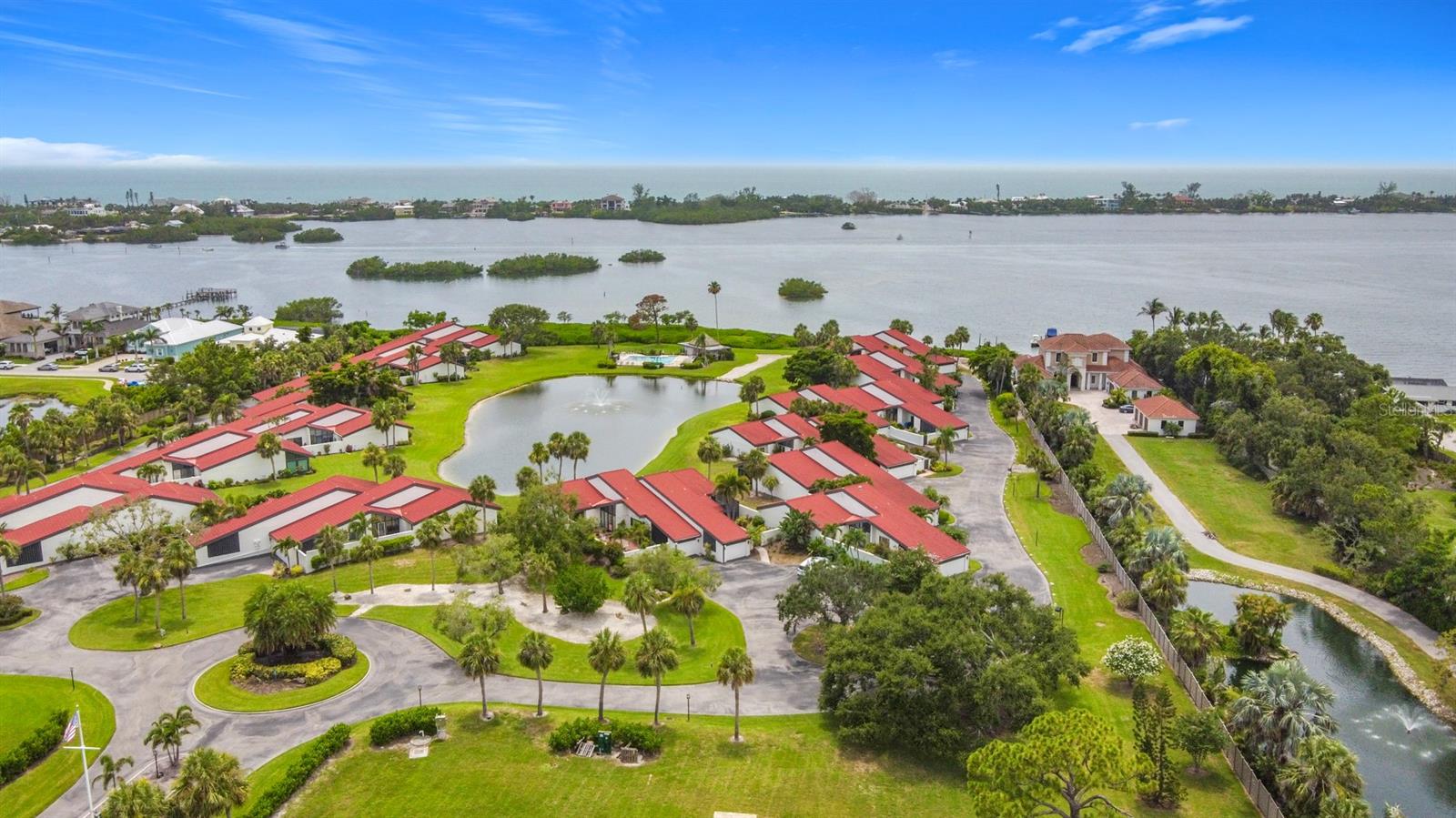 Waterfront Villa w/BOAT SLIPS - Large Private Courtyard & 2- Car Garage - Maintenance Free Living. Single story home-like living. Fish off the Pier or sit on the dock & enjoy the sunsets! NEW DOCK & PIER Welcome to Heron Bay Club, an exclusive enclave of just 25 uniquely designed villas situated on 11 acres along the Little Sarasota Bay across from Casey Key.  Enjoy carefree coastal living with maintenance-free grounds and an all-inclusive HOA that covers insurance, roof, exterior maintenance, landscaping, roads, pool and tennis facilities, docks/boat slips, cable TV, high-speed internet, water, trash and sewer. This spacious 2-bedroom, 2-bath villa features a versatile bonus room—perfect for a home office, den, or even a guest bedroom. Inside, you'll find a thoughtfully updated interior with a renovated kitchen featuring raised panel maple cabinetry and new countertop, The vaulted-ceiling living room offers tranquil lake views overlooking the bay, with many evenings capped by stunning sunsets over the Bay. STORAGE! in addition to the garage there is an interior attic! Outside, a 587 sqft courtyard with a hot tub invites outdoor relaxation and entertaining and expands the indoor-outdoor living space to 2,161 sqft Community amenities include a heated bayside swimming pool, tennis court, a fishing pier, kayak launch, and dockage for 10 boats—complete with electric and water—available to residents at NO COST. This is a very private location. Located directly on Little Sarasota Bay with no fixed bridges near MIDNIGHT PASS, residents enjoy the highly sought-after Osprey location close to Siesta Key and Sarasota’s rich cultural attractions. Nokomis beach is only a few miles away. Enjoy waterfront dinning at Casey Key Fish House, The Point and Deep Lagoon Oyster House. Highly-rated medical facilities, major airports, and shopping destinations are within close driving distance. You have arrived at your final destination.