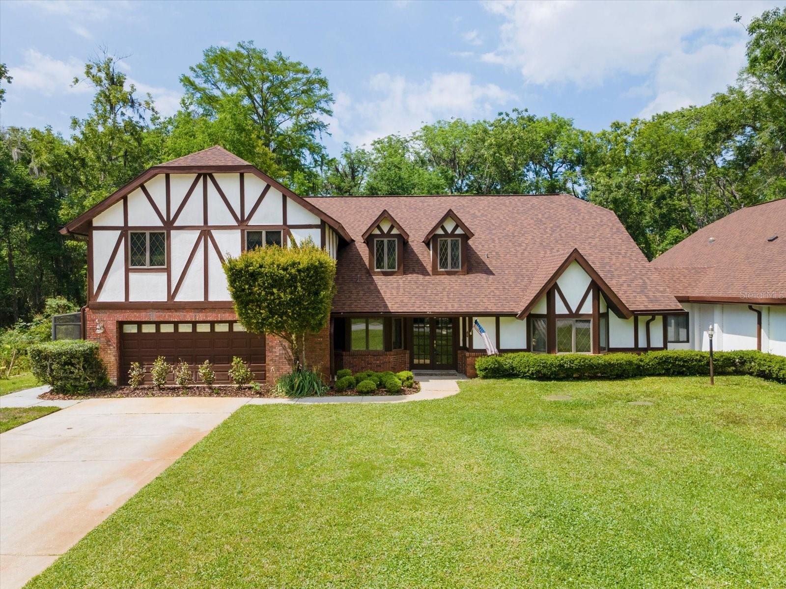 Discover refined living and rare amenities in this stunning 5-bedroom, 4.5-bath Tudor-style home nestled on 2 acres in the exclusive Hidden Lake community. Designed for comfort and sophistication, this residence features two primary suites, perfect for extended family or guests. Step inside and be greeted by soaring ceilings, rich finishes, and gracious spaces that flow effortlessly from one to the next. The enormous chef’s kitchen is the heart of the home — a dream for culinary enthusiasts — adorned with dramatic Brazilian quartzite countertops, custom cabinetry, and top-of-the-line appliances.  The oversized island, peninsula and side bar offer the ultimate in storage and custom features including a wine rack, appliance lifts and plate holder. A brick clad, wood-burning fireplace anchors the far wall. The entire space breathes a lived-in elegance—practical yet intimate—a room designed for both the quiet ritual of morning coffee and the convivial bustle of friends gathered around the peninsula.  Then enter the generous dining and gathering areas that invite conversation and connection. Beyond the glass doors lies a private outdoor sanctuary. The sparkling pool shimmers beneath the canopy of blue skies, surrounded by manicured landscaping and covered space for lounging or entertaining. Whether hosting summer soirées or quiet evenings under the stars, this residence embodies indoor–outdoor living at its best. The property includes its own airplane hangar, with 40' door span, making it a dream for aviation enthusiasts.  Hangar has attic storage and recreation room. Hidden Lake Airport (FA40) has an asphalt runway 4,425' x 50', allowing many types of aircraft to use the facility. PAPI and full runway lighting allows night operations, the runway is open 24/7. 100LL fuel available for purchase 24 hrs/day. The roads in Hidden Lake East also serve as active taxiways, allowing pilots to taxi their aircraft directly to the hangar at their home. Garage currently used as sixth bedroom, can be easily converted back.  Approx 4,500 sq ft heated per floor plan. All information believed to be accurate and should be verified by buyer & buyers agent. Being sold "as is" for sellers convenience
