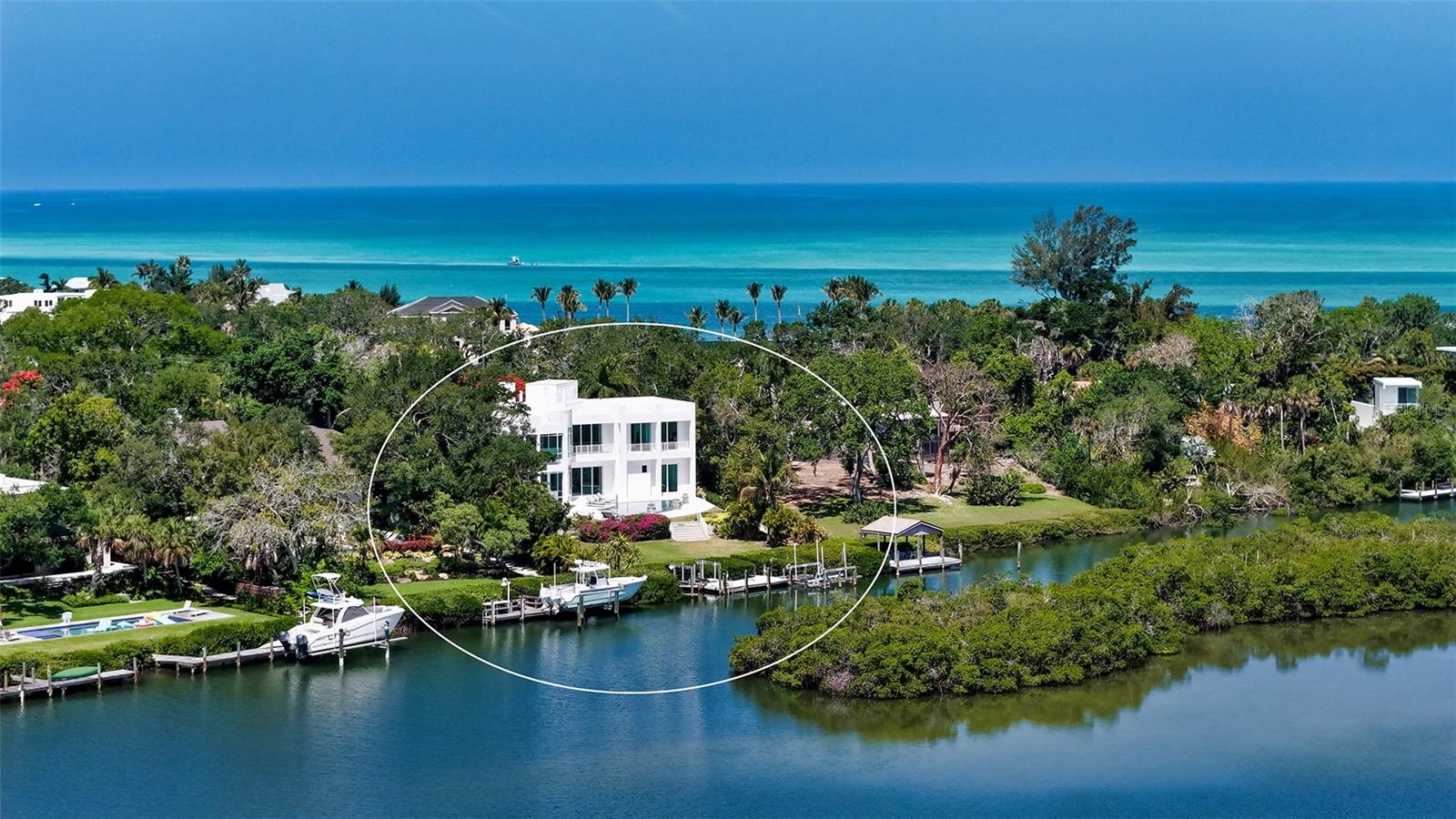 Virtually Staged. Celebrated as one of SRQ Magazine’s “Home of the Year” in 2008 and born from the visionary imagination of acclaimed architect Mark Sultana and built by Voigt Construction, this extraordinary waterfront estate is not simply a home — it is a lifestyle. One of Siesta Key’s most iconic private residences, it stands as a living testament to the art of inspired modern design and the art of living beautifully.

Deeply set on nearly one private acre along the tranquil Coconut Bayou, this gated 4-bedroom architectural masterpiece unfolds across multiple stories with absolute privacy, lush tropical splendor, and grounds generous enough for a pickleball court — all anchored by a fully separate guest house for family and friends who will never want to leave.

From the moment the gates open, life here feels different. A breathtaking composition of glass, steel, and sculptural lines soars beneath dramatic ceilings, with natural light pouring through at every angle — whether that’s a lazy Sunday morning or a dinner party in full swing. Rise by private elevator or ascend the sweeping steel-and-glass staircase to the crown jewel of this residence: a 2,500 sq. ft. rooftop terrace, where the Siesta Key lifestyle reaches its absolute peak. Panoramic views sweep across Siesta Key, the downtown Sarasota skyline, and the shimmering waterways below — this is where memories are made.

At the water’s edge, a brand-new dock on order, a double jet ski lift, and a dedicated kayak and paddleboard launch await — with direct, bridge-free access to the Intracoastal and the open Gulf beyond. This is the rare address that refuses to make you choose: the serenity of bayfront living, the thrill of open-water boating, and the privilege of private deeded beach access to the shores of Siesta Key — all from a single extraordinary estate.

Designed with both beauty and resilience in mind, the residence sits impressively high and dry above the Bayou. Even through recent storms, the property remained untouched by flooding — including the pool area — offering a rare sense of peace of mind along Sarasota’s waterfront.

The primary suite is a private world of its own — featuring a dedicated office/loft or exercise room, two custom walk-in closets, and a private balcony suspended above the Bayou. At the center of it all, an indulgent Champagne Jacuzzi infinity bathtub transforms every evening into a spa retreat. Downstairs, entertaining flows as naturally as conversation — from a dedicated movie theater room to tiered outdoor patios crowned by a spectacular summer kitchen, an open saltwater pool, and glowing fire bowl accents that keep the night alive.

In the kitchen, Italian custom cabinetry, top-tier appliances, a service pantry, and a private wine cellar come together in a space as pleasurable to cook in as it is to gather around. Garage parking for five vehicles and separate guest quarters complete an offering with virtually nothing left to wish for.

Minutes from The Out-of-Door Academy, Siesta Key Village, and Siesta Beach — this is not just an address. It is a life you’ll never want to leave.