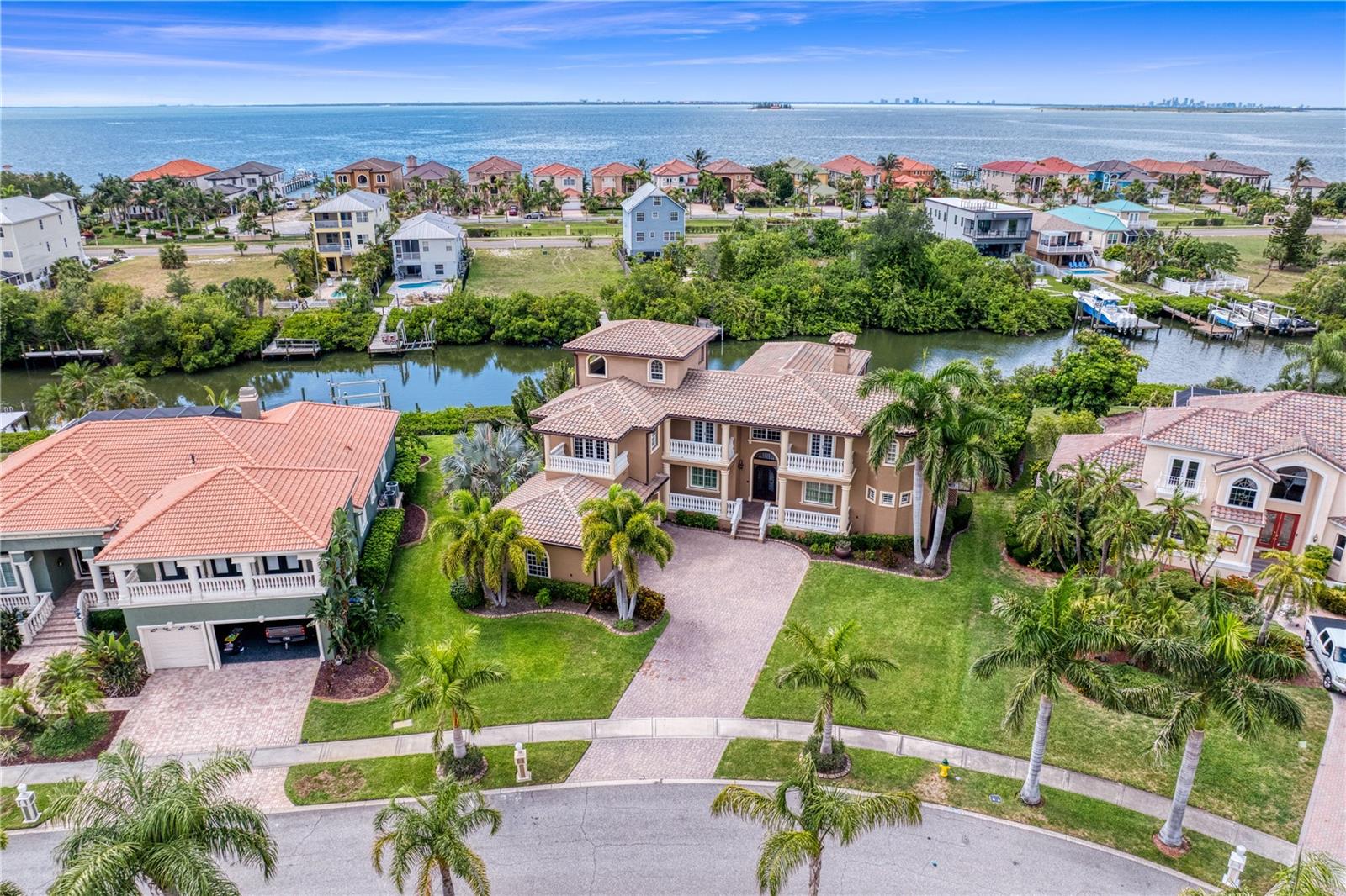 Virtually Staged. Welcome to an architectural masterpiece offering unparalleled coastal living in Apollo Beach’s premier waterfront community. This stunning 4-bedroom, 6-bathroom estate masterfully combines grand Mediterranean elegance with modern luxury, presenting a lifestyle of pure sophistication, deep-water access, and breathtaking panoramic views. From the moment you step through the majestic double wrought-iron entry doors, you are greeted by a soaring two-story great room framed by a massive wall of windows that floods the space with natural light and captures prime views of the water. The gourmet chef’s kitchen is a culinary dream, equipped with a premium Wolf professional gas range, Sub-Zero refrigeration, a sprawling central island, and high-end custom cabinetry. Seamlessly transition outdoors to your private backyard paradise, featuring a sparkling waterfront pool, an integrated stone-tiled spa, a fully equipped summer kitchen with a premium built-in grill, and an expansive private dock ready for your boat with effortless, direct access to Tampa Bay. Designed for ultimate flexibility and generational privacy, this estate features dual primary en-suites—one on the first level and one on the second. The first-floor primary retreat offers direct access through rear sliders to the pool deck, dual custom walk-in closets, and a spa-like bathroom, while the secondary upstairs bedrooms open to sprawling private balconies. Navigating this multi-generational estate is effortless thanks to a private elevator servicing the floors. For premier entertaining, the home boasts a dedicated home theater room for movie nights, an exclusive wine cellar to house your private collection, and the ultimate coastal feature: a spectacular crow’s nest providing 360-degree views of breathtaking Florida sunsets. Situated in Andalucia—Apollo Beach's premier gated waterfront community featuring 24-hour security, a yacht club, tennis courts, Jetty and a private clubhouse directly on the bay—this home offers a rare opportunity to live the ultimate vacation lifestyle every single day.
