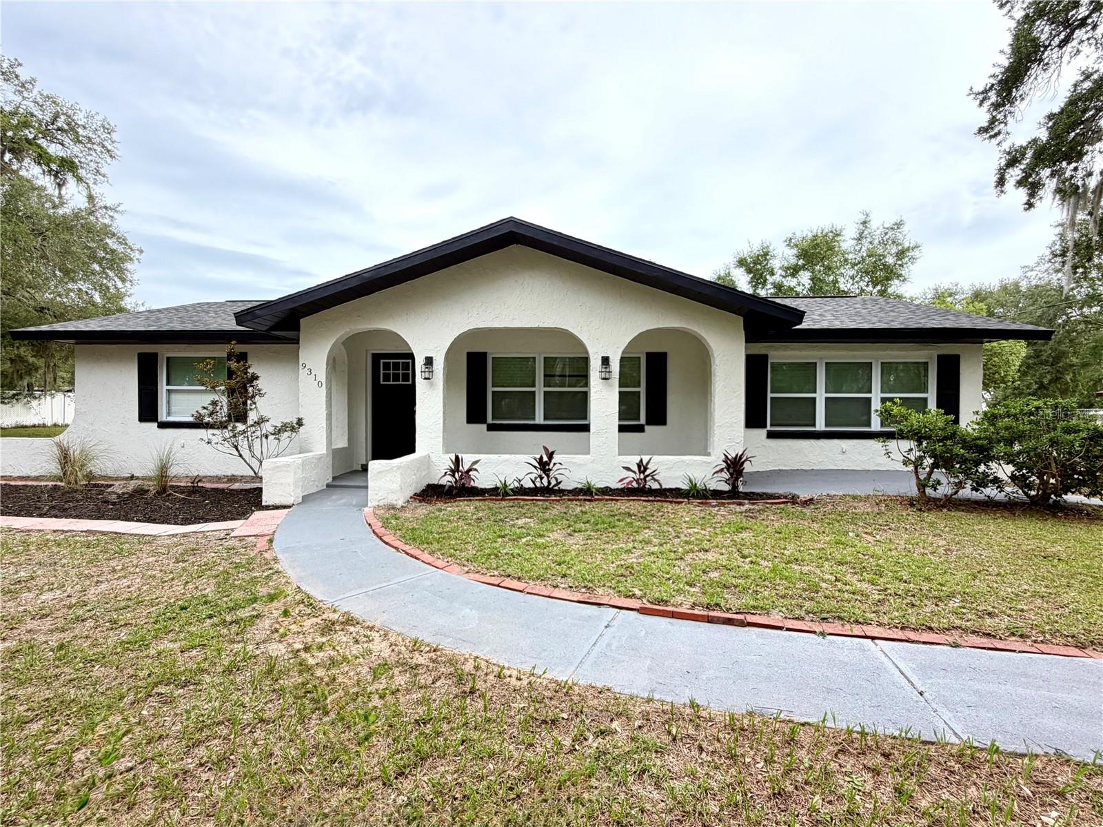 LOCATION, LOCATION, LOCATION! Situated on an DOUBLE LOT  just minutes from The Villages, this beautifully renovated home offers the perfect blend of space, privacy, and freedom with NO HOA and NO age restrictions. Enjoy easy access to shopping, restaurants, medical facilities, beautiful Lake Weir, and a short golf cart ride to Spanish Springs, Sumter Landing, and all the entertainment and recreation The Villages is known for. Completely updated from top to bottom, this move-in-ready property features a 2019 roof, fully remodeled bathrooms, brand-new kitchen cabinets, new granite countertops, a stylish backsplash, brand-new stainless steel appliances, luxury vinyl flooring throughout, updated lighting, spacious rooms, and fresh interior and exterior paint. The open and inviting floor plan offers large living areas filled with natural light, while the screened lanai provides the perfect space to relax. Outside, you'll find a fully fenced yard shaded by beautiful mature live oak trees, a detached storage shed, and a covered carport ideal for a golf cart, additional vehicles, or extra storage. Don't miss this incredible opportunity—schedule your private showing today!