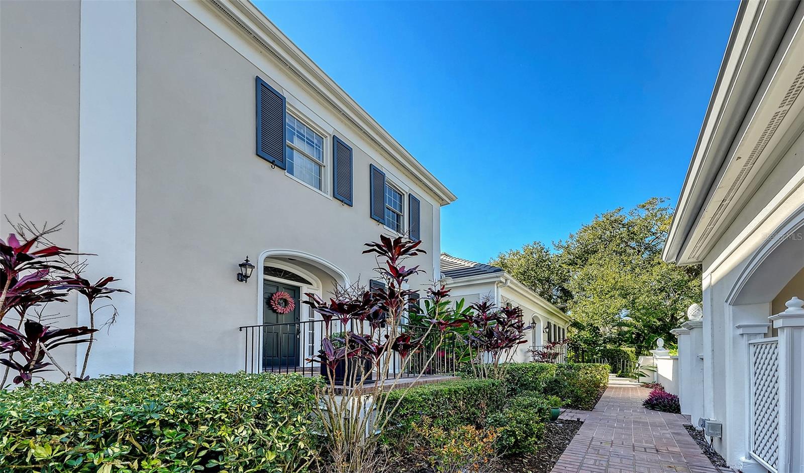 Enjoy the perfect maintenance free country club lifestyle in the charming and quaint Bishopscourt Townhomes located in The Oaks Preserve. Architecturally designed, this classic Georgian style townhouse features two bedrooms, two full ensuite baths, one half bath, a spacious great room, and a large terrace overlooking a lake. A welcoming foyer leads to the expansive great room where high ceilings, crown molding, French doors, and leaded glass transom windows provide natural light throughout the day. The dining room has a wet bar and is large enough to place a table seating 8-10 for entertaining or hosting holiday dinners for family or friends. The kitchen is well appointed and has granite counters, solid wood cabinetry, and stainless appliances. The second floor has two bedrooms, and the primary bedroom offers lush views of natural landscaping, the lake, two walk-in closets, and the primary bath has been renovated beautifully with a lovely high vanity, dual sinks, abundance of cabinetry and a large shower. The second bedroom is a comfortable space for visiting family or friends and has a well-appointed ensuite private bath. There is a separate, enclosed laundry room and a half bath downstairs. This lovely townhome offers you membership in the sought-after and extremely popular Oaks Country Club with two memberships to choose from, either Social or Golf, and a maintenance free home you can lock and leave without worry and have a carefree lifestyle choosing social activities including pickleball, tennis, croquet, bocce, bridge, day trips, women's clubs, men's clubs, dining, biking, and much more. With Golf you will have two beautiful championship 18-hole golf courses and all of the above! What a life! The Oaks Preserve is centrally located to Sarasota's sugar sand beaches, downtown for arts, shopping, and minutes to the Sarasota airport. A Social or Golf membership is required and available to you now!