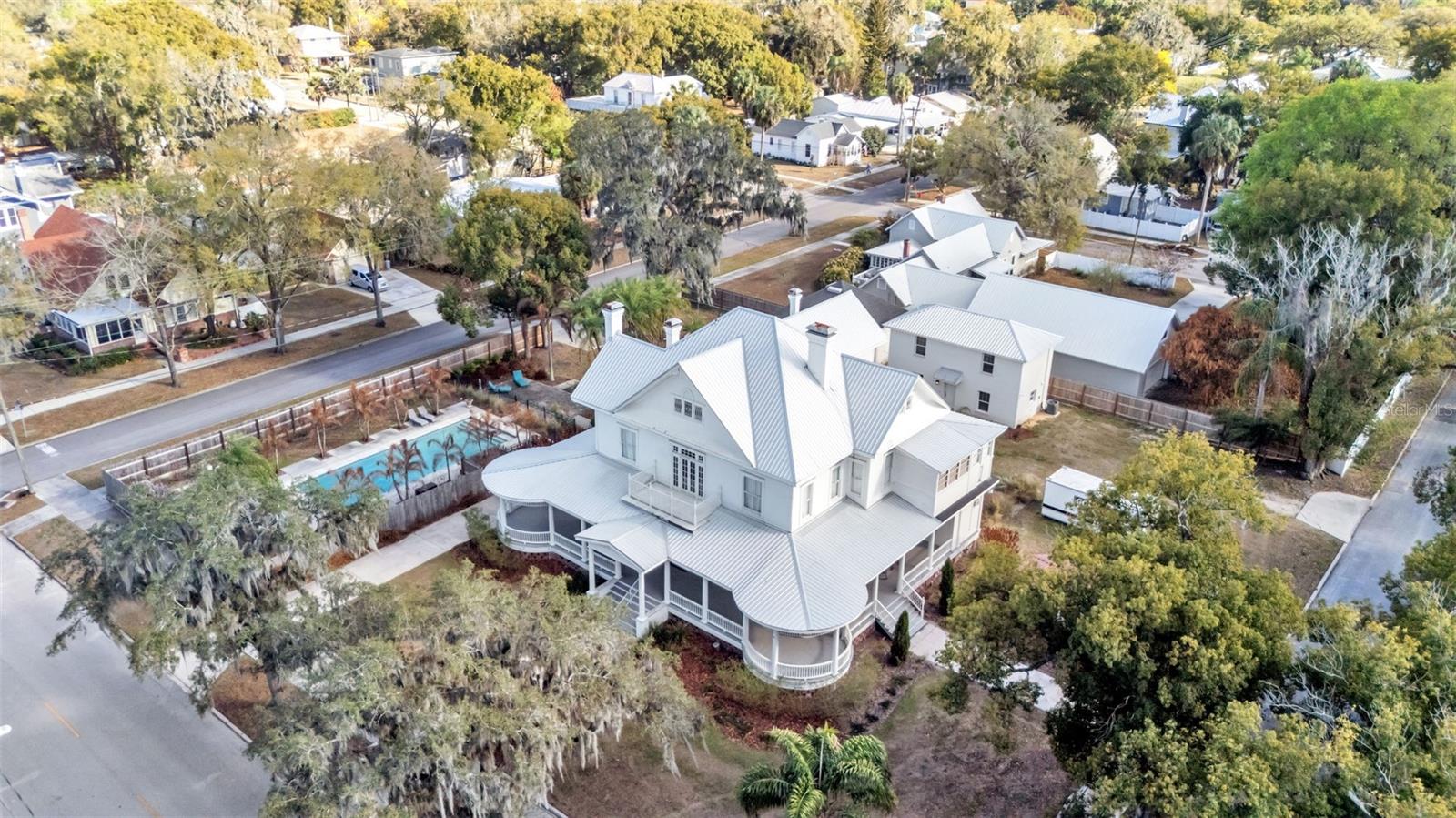 One or more photo(s) has been virtually staged. HUGE PRICE DROP!  This exquisite Victorian-style residence, constructed in 1906 (reportedly by Polk County lawyer Thomas Lee Wilson), stands as a timeless architectural gem. Famously known as the My Girl house from the beloved 1991 film where it served as the exterior of the Sultenfuss family home. It has also graced history as the Stanford Inn Bed & Breakfast and, more recently, as His Hope House. 
The primary home spans approximately 5,776 square feet of air-conditioned living space, masterfully blending its rich historic charm with thoughtful, extensive renovations that honor and preserve its original character and elegance. Complementing the main residence, the
property features a charming separate one-bedroom guest house, an additional building currently utilized as versatile meeting and donation space, and a spacious, inviting pool. All set on beautifully landscaped grounds that enhance its enduring appeal. This captivating tour begins on the expansive 1,500+ sf wraparound porch; a perfect spot for entertaining, events, or quiet mornings with coffee. Inside, the grand foyer opens to elegant spaces: a front sitting room, formal living and dining rooms, a private office, and a beautifully updated kitchen with modern cabinetry, premium appliances, a large center island with bar seating, and a secondary dining area. Timeless features include wainscoting, new lighting, some original hardwoods, a sprinkler system, and remodeled period bathrooms. The main level offers a spacious primary suite with fireplace and full ensuite bath, two guest half baths, and first- floor laundry. Upstairs, a versatile loft area complements five additional bedrooms, each with unique charm, featuring fireplaces and private ensuites. Plus a second laundry for added
convenience, ideal for multi-generational or flexible living. The 1,000 sf two-story guest house (built 2022) includes a kitchen, living room, bathroom,upstairs bedroom, and loft space; perfect for guests or additional use. The remodeled former carriage house (third building) offers 500 sf with power, A/C, and space for offices, storage, or other needs. The property is zoned R-3, in the City of Bartow which offers tremendous future potential beyond its current configuration. This may include hospitality and short-term rentals (Bed and Breakfast or Airbnb capitalizing on its famous “My Girl” movie history), group or supportive living (family-care, maternity, residential program, hospice, rehab or similar), multi- generational or extended family estate, or Event space (host private events, retreats, small-scale commercial uses while maintaining residential charm). Verifying your use within the City of Bartow’s zoning uses. This historic gem blend of preserved Victorian elegance, modern updates, and adaptable layout positions it for endless possibilities, whether as a cherished family home, income-
generating venture, or meaningful community resource.
** Photos in the guest house have been virtually staged to illustrate the property’s potential **