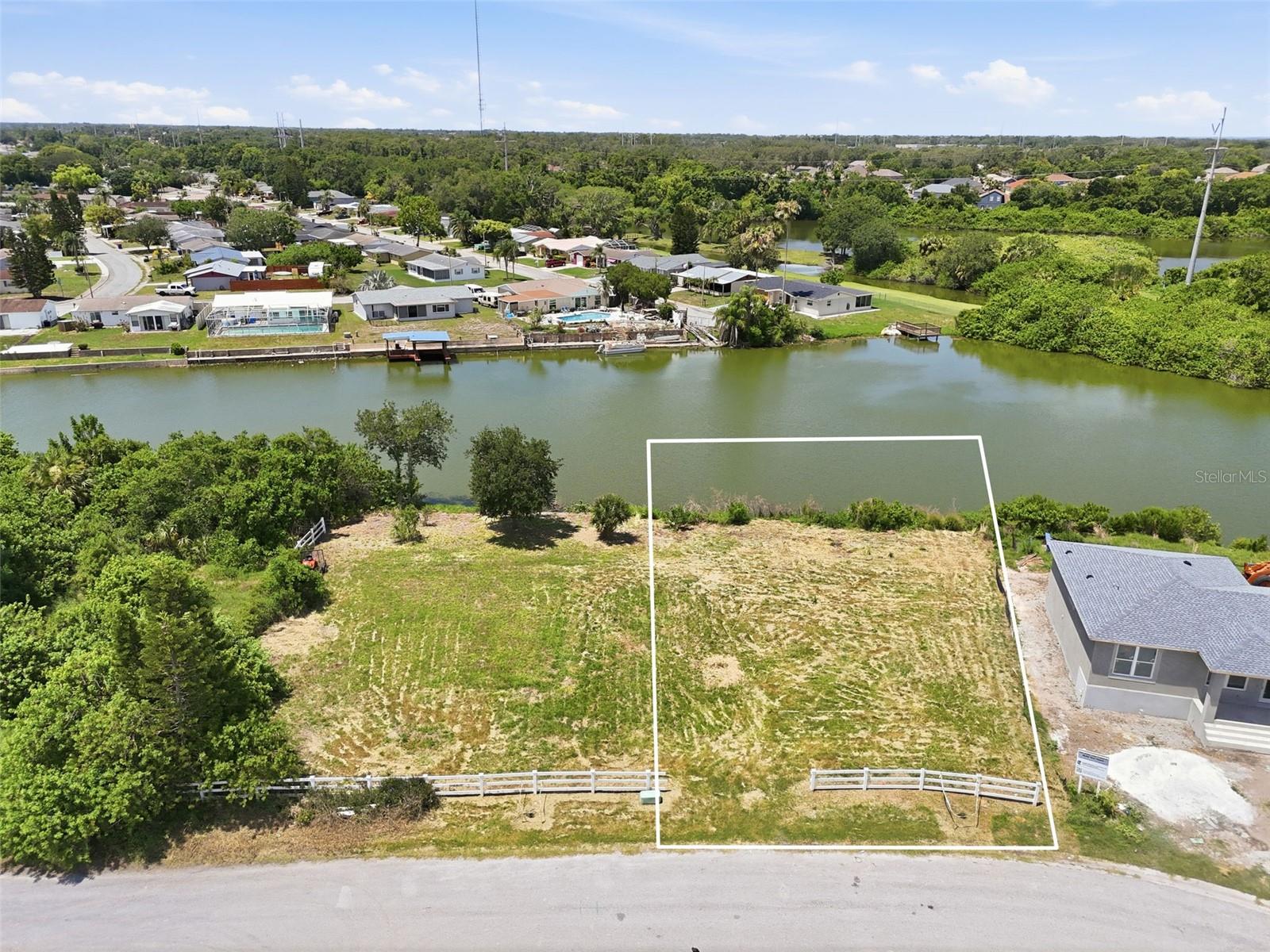 Discover the perfect setting for your custom waterfront dream home on this expansive .39-acre canal-front lot located on a quiet cul-de-sac in Holiday. Offering ample space for a variety of home designs, outdoor living areas, and landscaping possibilities, this oversized property provides a rare opportunity to create your ideal Florida retreat. An added bonus - the adjacent lot is also available for purchase, allowing for an even larger homesite or future investment potential. Enjoy peaceful canal views and a tranquil setting in an up-and-coming neighborhood with numerous newly constructed homes. According to the owner, the property has never flooded during past storms, providing additional confidence as you plan your future build. With the property line extending into the water, there is potential to add a private dock, creating the perfect spot for fishing, launching kayaks or paddleboards, enjoying nature, or simply relaxing by the water. Whether you're seeking a waterfront lifestyle or a unique homesite with room to grow, this property offers exceptional possibilities. Conveniently located near shopping centers, restaurants, parks, and zoned schools, the property is also just minutes from the J. Ben Harrill Recreation Complex. Historic Tarpon Springs, known for its waterfront dining, unique shops, festivals, and year-round activities, is only about 15 minutes away. Gulf beaches and endless outdoor recreation opportunities are also within easy reach. Don't miss this rare chance to secure a spacious waterfront lot in a growing area and build the home you've always envisioned.