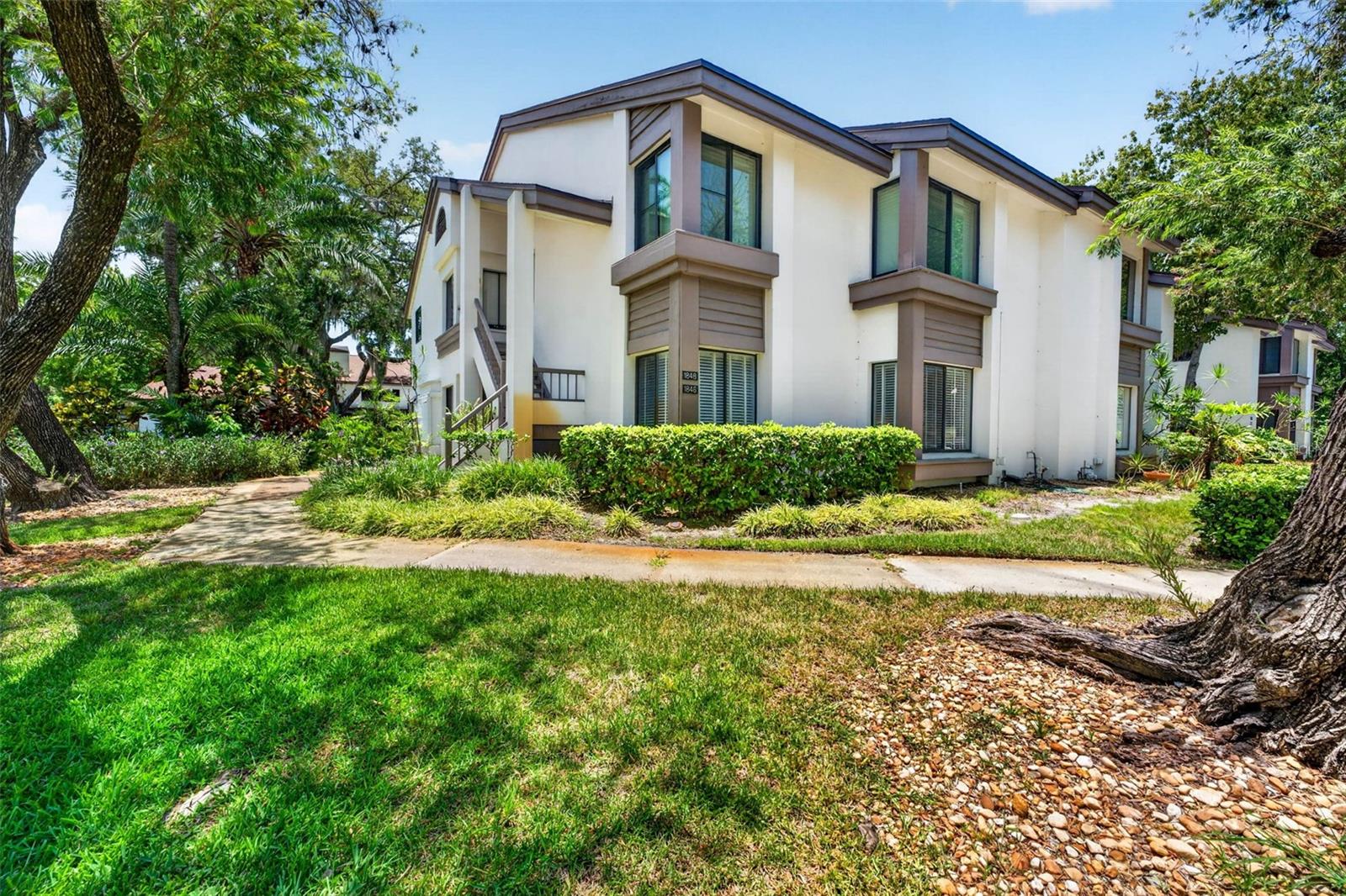 Beautiful first-floor end-unit condo in the highly desirable Cypress Trace community! Move right into this spacious 2-bedroom, 2-bath home featuring an updated kitchen with white shaker cabinetry, granite countertops, subway tile backsplash, stainless steel appliances, indoor laundry, and the added comfort of two separate HVAC systems for independent climate control of the living and bedroom areas. Soaring vaulted ceilings, abundant natural light, a cozy wood-burning fireplace, and sliding doors leading to a private screened lanai overlooking peaceful green space create a warm and inviting atmosphere. The oversized primary suite features a walk-in closet and spacious en-suite bath, while the generous second bedroom is perfect for guests or a home office. Enjoy maintenance-free living with a covered carport, community pool, spa, tennis courts, and an HOA that includes exterior maintenance, roof, water, sewer, trash, cable, and more. Ideally located just minutes from charming downtown Safety Harbor, the marina, waterfront parks, restaurants, shopping, and Philippe Park, this home offers the perfect blend of comfort, convenience, and Florida lifestyle.