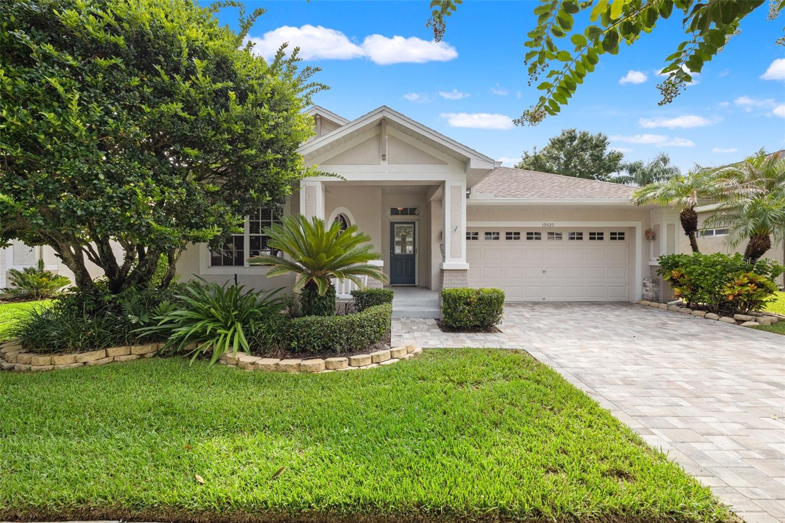 Welcome to Traditions, a gated pool community within the Villarosa neighborhood.  The HOA takes care of your lawn and painting the exterior of your home.  This beautiful three bedroom home sits on a cul de sac and welcomes you with a newly brick paved driveway and charming front porch.  Inside you will find an open plan with real wood floors, crown molding, and double french doors that lead you to an extended covered patio.  The kitchen features wood cabinets, corian counters, stainless steel applicances with a bar seating as well as space for a kitchen table.  The main bedroom suite has wood floors, two walk-in closets, and a large bathroom with a garden tub, stall shower and two sink areas.  The front two bedrooms and hall bath are privately tucked away from the rest of the home.  With no rear neighbors, enjoy the screened patio with built in planters in peace.  Recent Improvements include AC with UV system 2025, Water Heater 2025, Paved Driveway 2025, Water softener 2025.  In addition to the pool that is specifically for the homes within Traditions, the Villarosa Park is near by with Tennis & Basketball Courts and a Playground.  The Community is right off the Veterans Expressway, and assigned to highly rated schools and close to shopping and restaurants.
