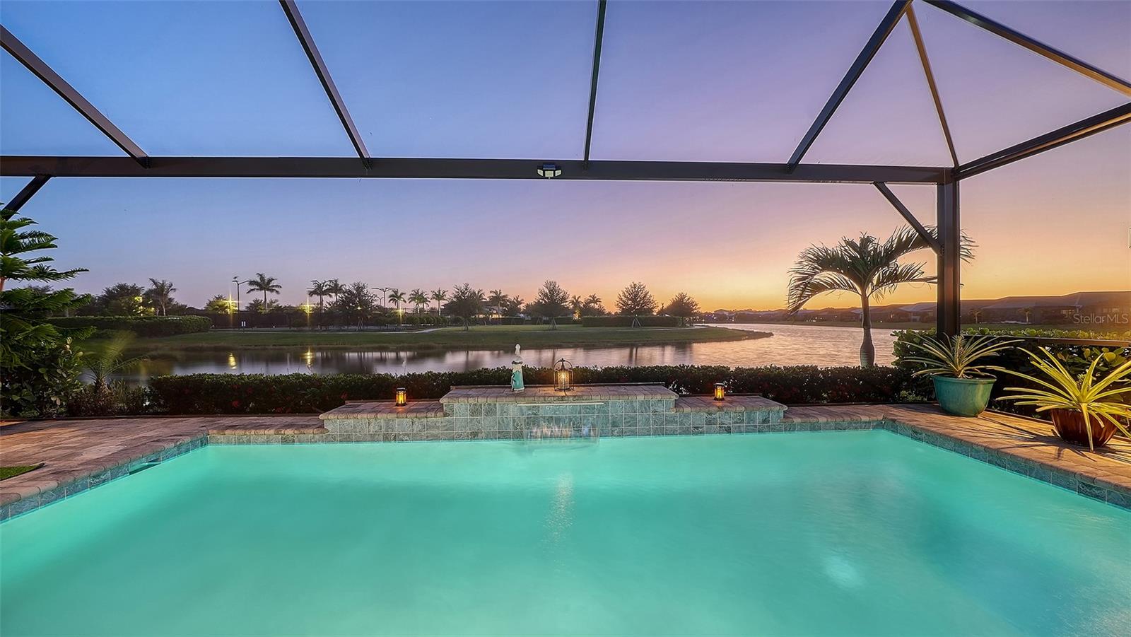 Welcome To Your Ultimate Florida Dream Home In The Premier 55+ Resort Community Of Cresswind! Prepare To Be Captivated By The Breathtaking LONG SUNSET WATER VIEWS From Your Own Private Outdoor Oasis. This Backyard Masterpiece Features A Spectacular REMOTE HEATED POOL Enclosed Within A Clear-View PANORAMIC CAGE, Ensuring Unobstructed Vistas Over The Water. Entertain Or Unwind Under The Lanai Equipped With CUSTOM SUN SHADES And An Electric Awning For Total Comfort While You Watch The Sun Go Down. Step Inside This Meticulously Upgraded 3-Bedroom, 3-Bath Sanctuary To Discover An Open-Concept Floorplan Dripping With Sophistication. The Centerpiece Of The Great Room Is A Magnificent CUSTOM FIREPLACE WALL Adorned With Built-In Stone, Perfectly Complemented By Designer Lighting And Upgraded Flooring Throughout. Calling All Chefs! The GOURMET KITCHEN Is An Absolute Showstopper Featuring A Massive 16-Foot Island, Premium Upgraded Cabinetry, A Custom-Built Pantry, And A Highly Desirable DOUBLE DOOR CONVECTION OVEN. Relax In The Primary Suite Complete With A Custom Master Closet. Every Detail Has Been Thoughtfully Designed, Including Electric Rolling Shades On The Sliders, Privacy Window Film, And Elegant Shutters. Enjoy Absolute Peace Of Mind With A WHOLE HOUSE GENERAC GENERATOR, Heavy-Duty Accordion Storm Shutters, A Top-Tier Water Filtration And Softener System, Plus A UV Air Purifier. The World-Class Cresswind Lifestyle Awaits You With A Full-Time Lifestyle Director, Pickleball, Tennis, Resort-Style Pools, A State-Of-The-Art Fitness Center, And Dedicated Rooms For Art And Cards. Offered Partially Furnished, This Turnkey Masterpiece Is More Than A Home, It Is A Lifestyle Without Compromise.