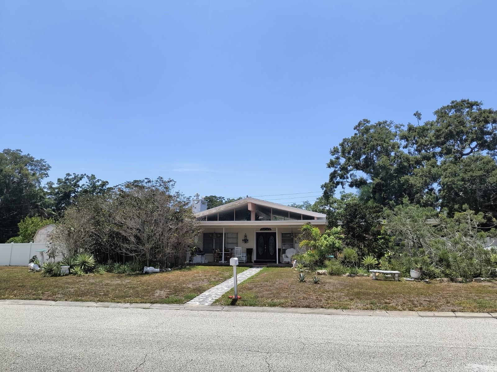 A rare find in the much sought after city of Dunedin, FL. The City features a lively walkable dog and bike friendly downtown. A coastal city  near the award winning beaches of Honeymoon Island and Caladesi State Parks. This unique 3 bedroom 2 bath 2 car garage home is situated on a large double lot property. The home has a spacious Great Room layout with Cathedral Ceilings and sliding doors leading out to a large Bird Caged Screen Enclosure Pool. The side yard is fenced in with an attractive vinyl fence, where there is room for a recreational vehicle to be parked (City allowed only behind the fencing). A corner lot with lovely mature landscaping. Come see the potential this property has to available!