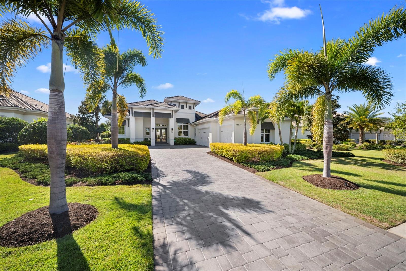 Under contract-accepting backup offers. Welcome to 16826 Clearlake Avenue, an extraordinary residence nestled within the prestigious, gated community of The Lake Club in Lakewood Ranch — where refined luxury and modern design reach new heights. Built in 2020 and dramatically enhanced through a stunning series of renovations, this one-of-a-kind masterpiece stands apart from every other home in The Lake Club. From the moment you enter the foyer, the wow factor is undeniable. Soaring 12- to 13-foot ceilings in the principal rooms create an immediate sense of grandeur, while the dramatic 10-foot double sliding glass doors frame a breathtaking panorama of the resort-style pool and spa, lush landscaping, and serene water views beyond — a living work of art that greets you every single day. The open-concept kitchen, living, and dining areas have been meticulously reimagined with no detail overlooked. Every surface is finished in exquisite quartz, all light fixtures have been thoughtfully upgraded, and the primary bedroom and living spaces reflect a level of sophistication rarely found in any market. Retreat to the primary suite, a true sanctuary where elegance meets tranquility. Gorgeous wide-plank blonde engineered hardwood floors flow through all the bedrooms, adding warmth and understated sophistication to every private space. A private walkout opens directly to the lanai and pool area, where sweeping water views create a serene and indulgent backdrop — whether you're starting your morning with a quiet cup of coffee or winding down at the end of a perfect Florida day. This exceptional home features 4 bedrooms, 4.5 bathrooms, and a private office. The fourth bedroom has been thoughtfully transformed into a sophisticated media room, complete with its own walkout to the pool — ideal for movie nights or entertaining guests in style. A spacious 3-car garage and a fully fenced backyard provide both practicality and privacy. Step outside to your personal resort — an expansive lanai complete with a stylish pool and spa, elegant outdoor living and dining areas, a fully equipped outdoor kitchen with island, and a rare climate-controlled storage room accessible directly from the lanai. Designed for those who demand the very best, every inch of this home has been curated for the discerning buyer. Peace of mind comes standard with a whole-home Generac generator and surge protection, ensuring uninterrupted comfort regardless of the season. Beyond your private retreat, The Lake Club delivers an unrivaled lifestyle with its grand Clubhouse featuring a restaurant, bar, fitness center, and spa services, plus two resort-style pools, tennis and pickleball courts, a half-court basketball court, a dog park, and miles of beautifully landscaped walking paths. There is simply nothing else like this in The Lake Club. Come fall in love with this masterpiece and begin living life superbly.