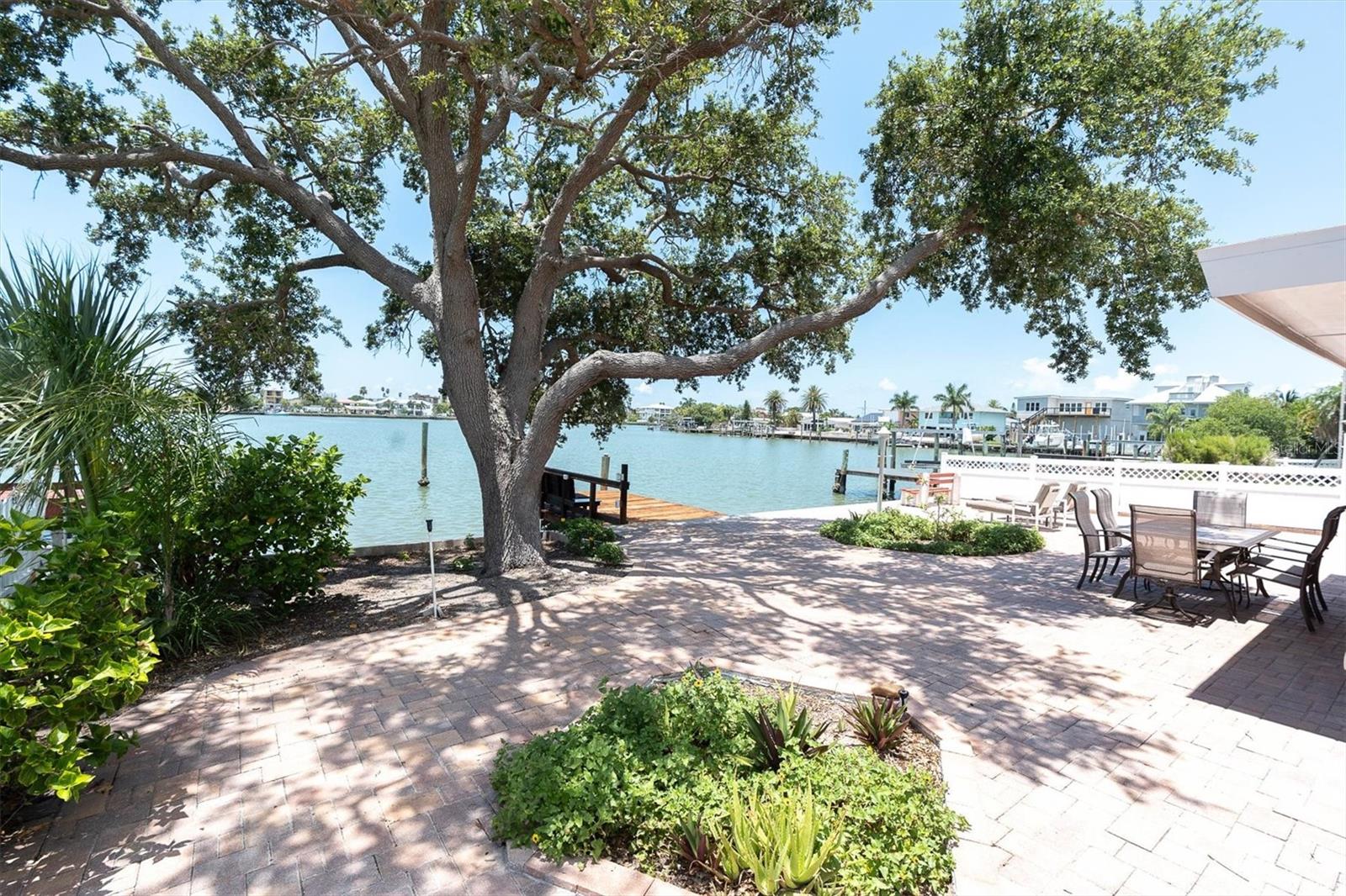 Your beautiful waterfront resort awaits. Live here year round like the locals and be on vacation every day or add this versatile property to your short term real estate rental portfolio. With the wide open waterway, and 60 feet of waterfront, your dream boat can be easily accommodated. No boat? No worries. One can enjoy sunsets and sunrises, the visiting dolphins, and fishing off your beautiful (2008) SEAWALL or dock with electric. So many upgrades this year have been added to give the next lucky owner peace of mind. To name a few, there’s a new wall in the back with large impact rated windows bringing in amazing light, NEW WATER HEATER, NEW KITCHEN CABINETS, STONE COUNTERTOPS, NEW APPLIANCES NEW PLUMBING AND CLEAN OUT TO STREET, and NEW CUSTOM FLOOD GATES FOR ALL DOORS, INCLUDING GARAGE. The ROOF is 2020 and upgraded ELECTRIC PANEL IN 2026. This home is pristine and everything permitted and remediated professionally. Just as glistening as the water, will be the beautifully honed to perfection terrazzo floors in kitchen, dining room, living room and all first level bedrooms and bath. The entire upstairs is the master suite complete with balcony, spa like bath, huge walk-in closet and reading nook. Another unique aspect of this lovely home is flanking both sides of a grand welcoming foyer are a huge waterfront living room and an equally large family room with separate entrance. Also boasting a special entrance is one of the bedrooms with bath, closet and hallway, perfect for mother in law suite, visitor or office. Beauty and comfort exudes all over, yet there is so much attention to detail behind the high ceilings and walls. The neighborhood has a private beach access with free parking for residents, waterfront park for wine tastings, golf cart parades and the Redington Beach holiday boat parade turns around feet from this dock. This home has it all.