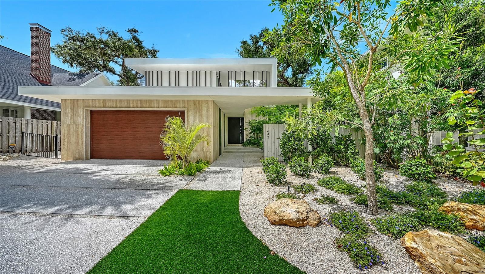 Stunning New Construction by Award-Winning Architect Dan Lear in coveted West of Trail Neighborhood**  This meticulously designed luxury home offers the perfect blend of modern elegance and timeless sophistication. Near Selby Gardens, Morton's Market, and Sarasota Memorial Hospital, this exceptional property provides both convenience and style. Spanning over 3,800sqft of living area, this expansive residence boasts four spacious bedrooms, five full bathrooms, a enormous den with terrace, and a dedicated office space, all thoughtfully crafted for contemporary living. The grand, open-concept great room is the heart of the home, seamlessly floating over the pool area with a stunning large corner pocketing glass door that connects the interior to the beautifully landscaped outdoor oasis. The second floor features three guest suites, each with its own private terrace, offering tropical views and tranquility. The home's striking exterior showcases luxurious vein-cut travertine, creating a refined, sophisticated look. This is an extraordinary opportunity to move right in to a worry free one-of-a-kind masterpiece.