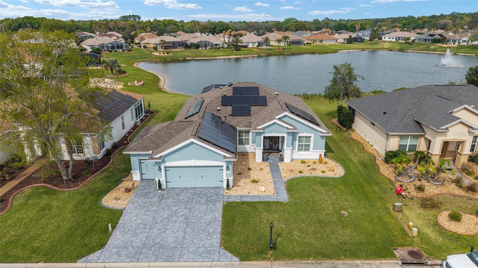 Pool House with Stunning Water Views! Situated in Del Webb’s Spruce Creek Golf & Country Club, an exclusive 55+ community between The Villages and Ocala, this home boasts double beveled-glass entry doors that open to a foyer with tiled floors and water views. The spacious kitchen offers plenty of 42" cabinetry. The primary suite features a water view, engineered hardwood floors, and a large walk-in closet. The den can be used as a third bedroom with the addition of the built-in Murphy Bed. An extended two-car garage, plus a golf cart garage with extra storage, provides ample space. Enjoy a designer-painted driveway and walkway, along with a large, screened lanai overlooking the water—ideal for entertaining guests. Recent updates include a new roof (2023), fresh interior and exterior paint (2023), a whole-house generator and Solar Panels (owned). Well for irrigation , liquid light in pool enclosure.This unique waterfront home is move-in ready and meticulously maintained—don’t miss your chance purchase this beautiful home!